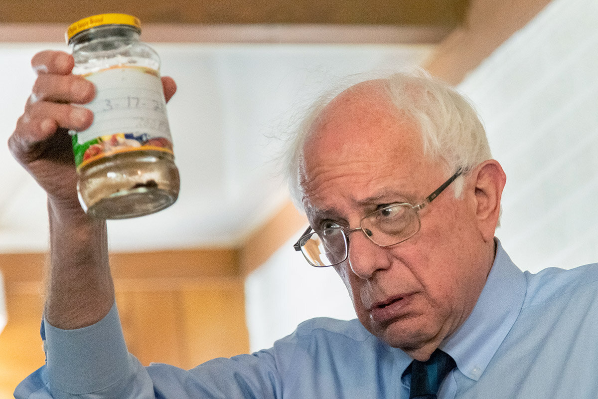  Democratic presidential hopeful Sen. Bernie Sanders views a jar of polluted tap water samples collected by homeowners Paula Brown and her partner Eugene Smith during a visit to their home May 18, 2019 in Denmark, South Carolina. Smith and Brown, are