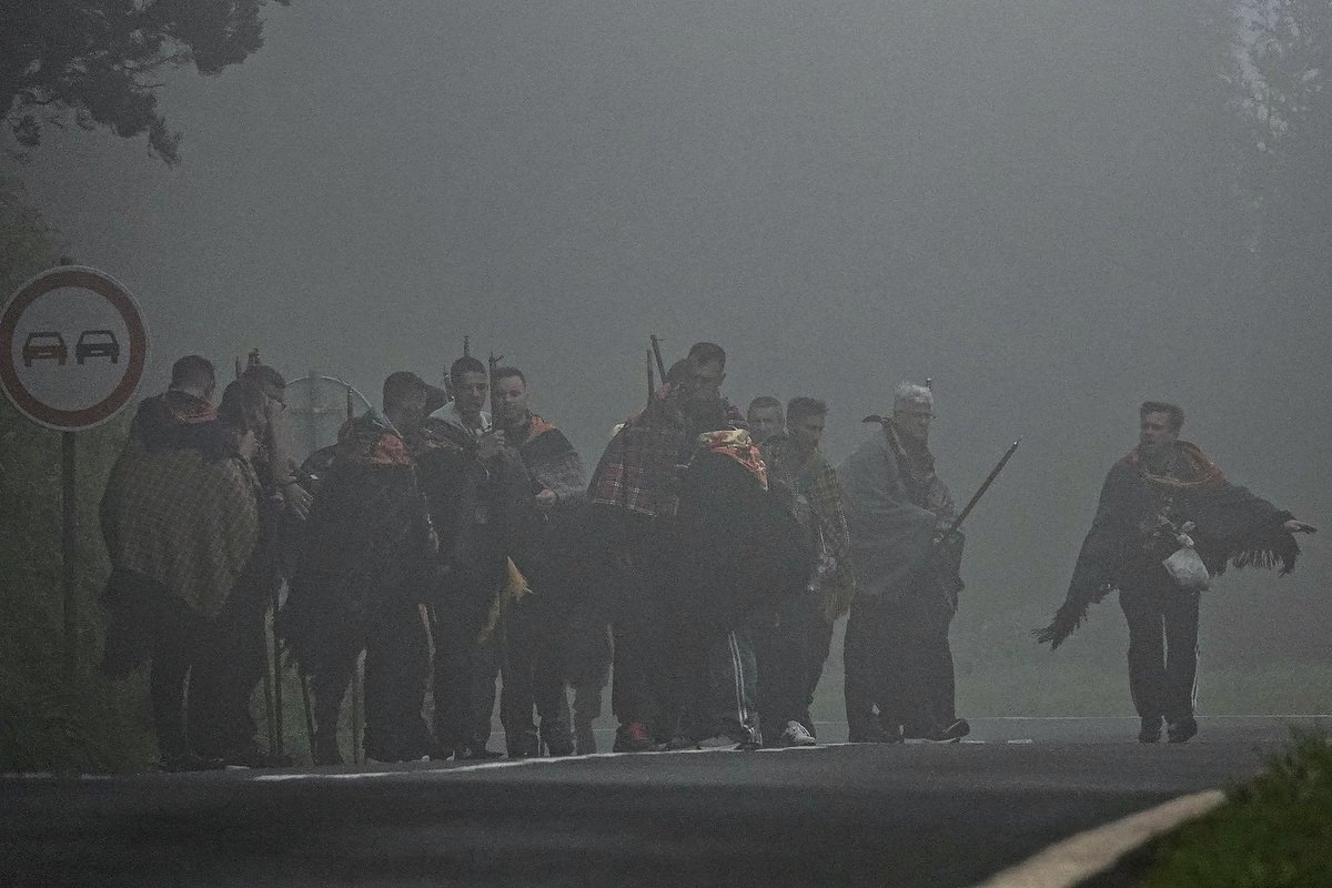  Roman Catholic pilgrims called a Romeiros, cross a rural road in fog and blowing rain during their 8-day trek around the Azorean Island of Sao Miguel, March 26, 2023 in Povoação, Portugal. The pilgrims visit 100 shrines and churches during the event