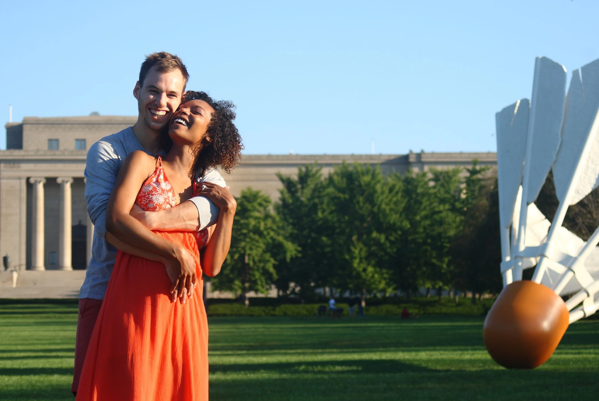 Maternity Photoshoot outside of an art museum with dramatic side-lighting during golden hour.