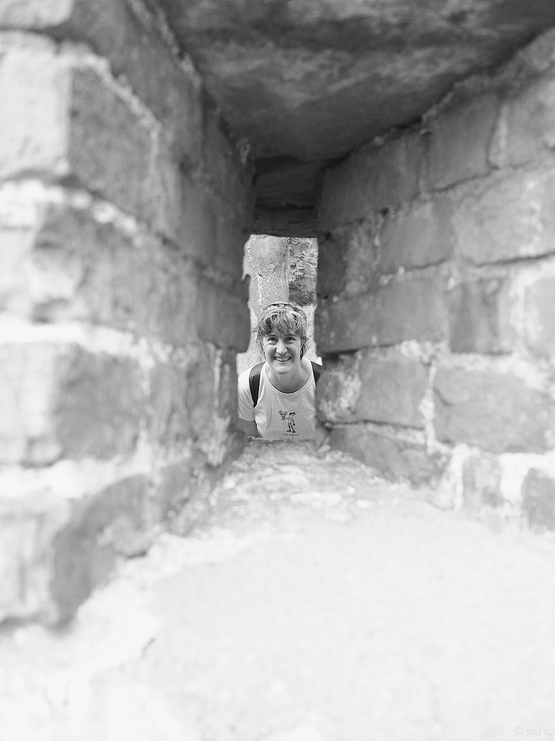 Sara peers through an opening in the old fortress wall
