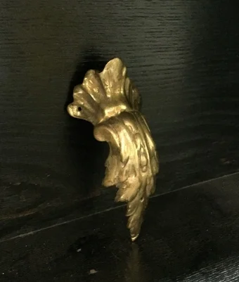 The unfinished brass mount used on the knees of the legs for Desk 38