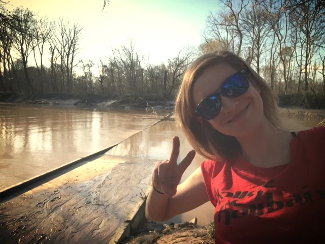 Lauren posing in front of where Troy used to be stuck, wearing her improved commemorative tee