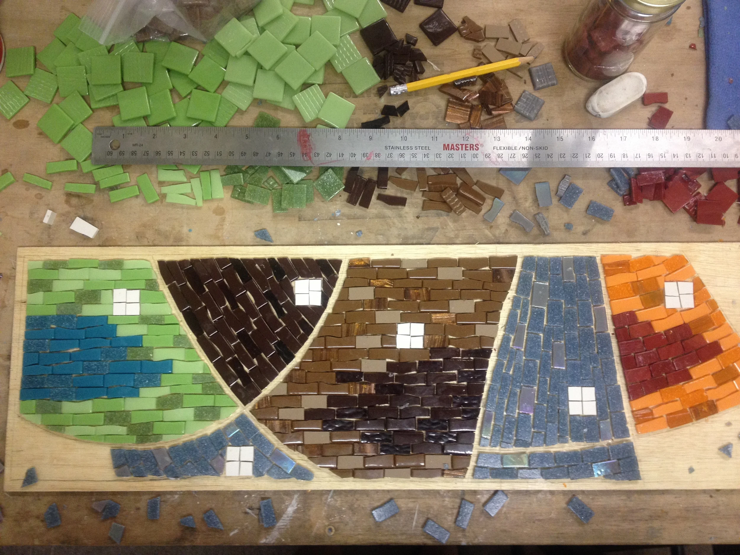 Johannah used grout lines and andamento, the visual flow created by the placement of the tesserae (tiles), to create a sense of movement and balance of colors similar to the rug.