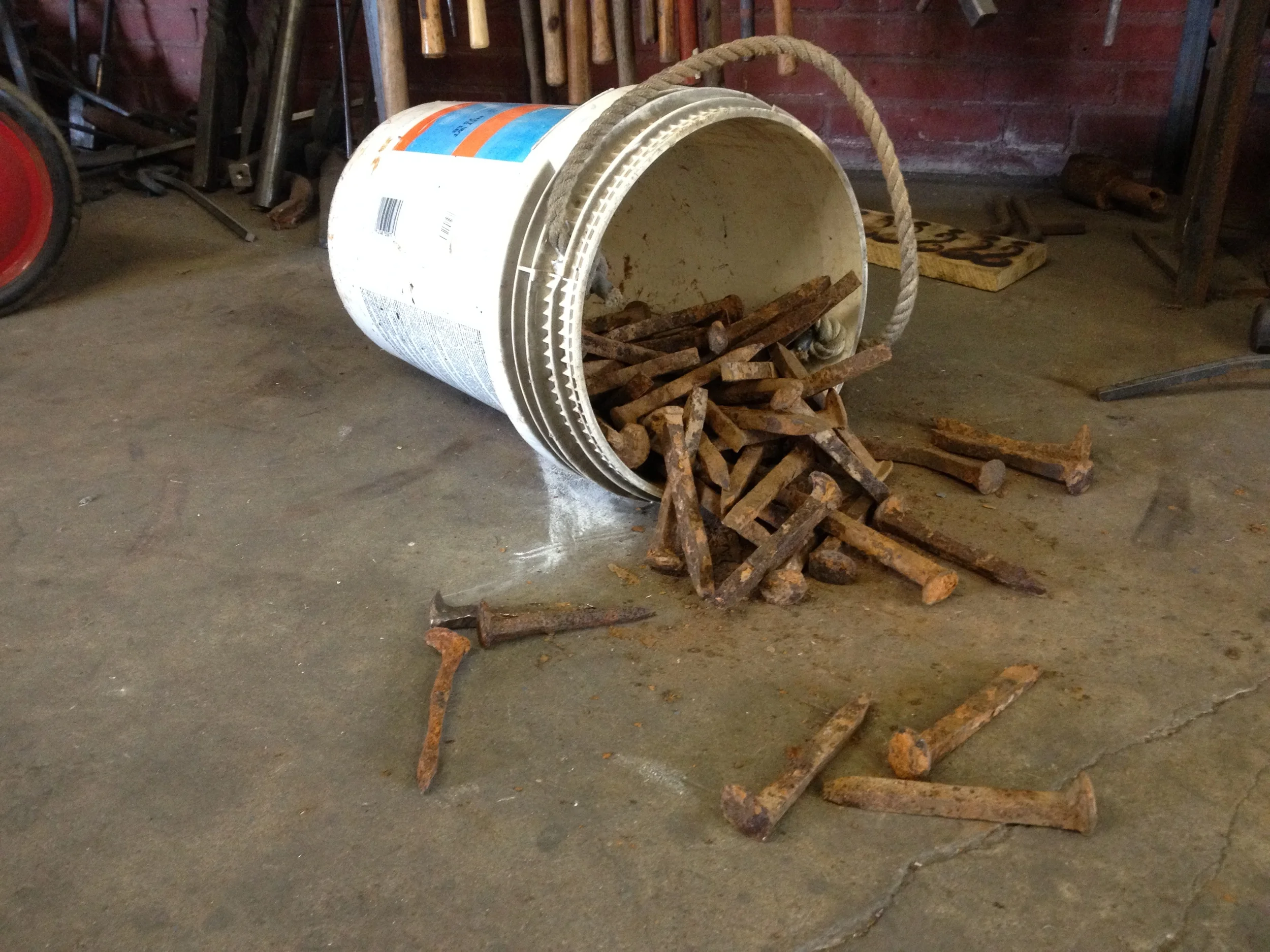 Bucket of railroad spikes fresh from river.