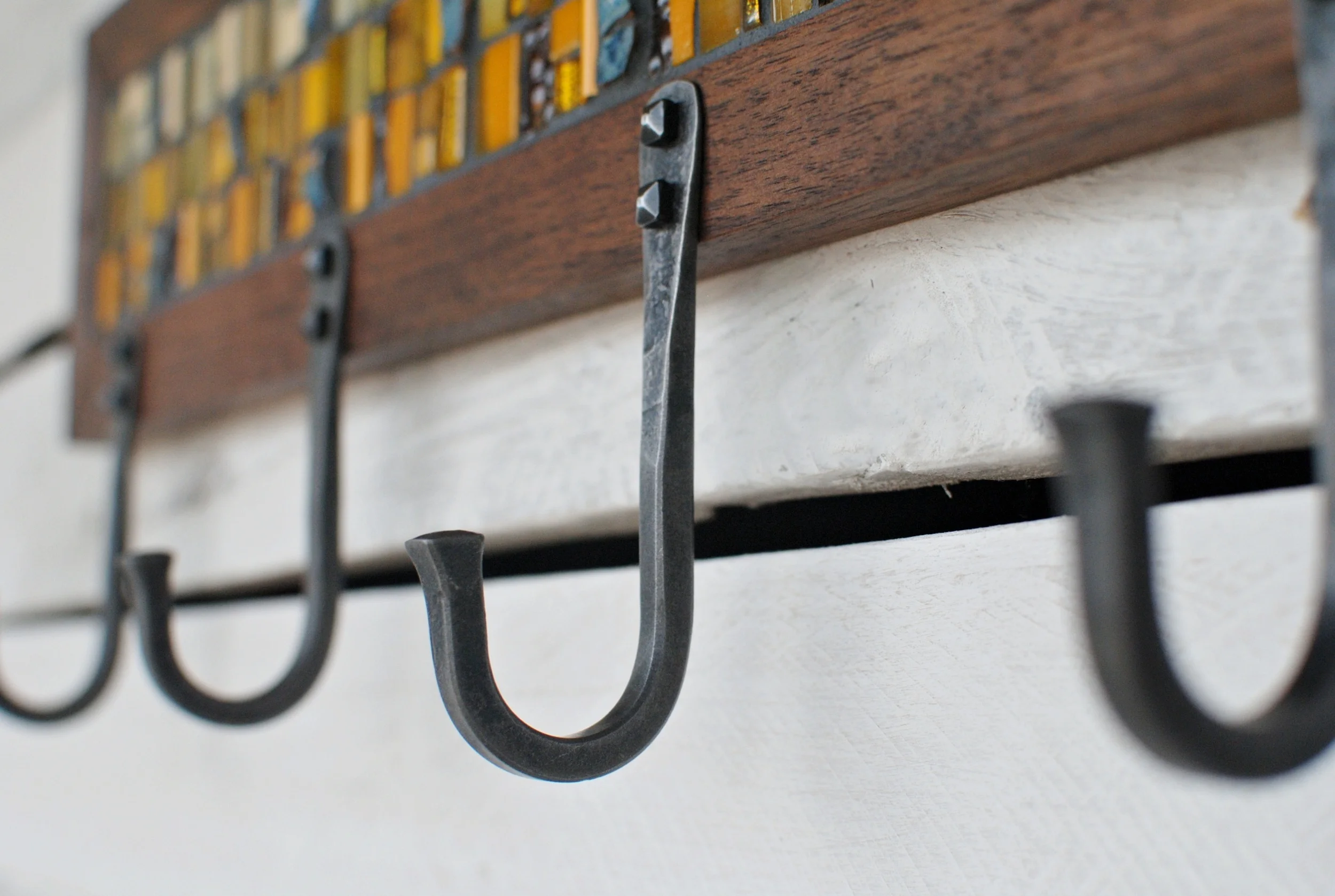 Detail of hand-forged steel U-hook on a custom mosaic coat rack