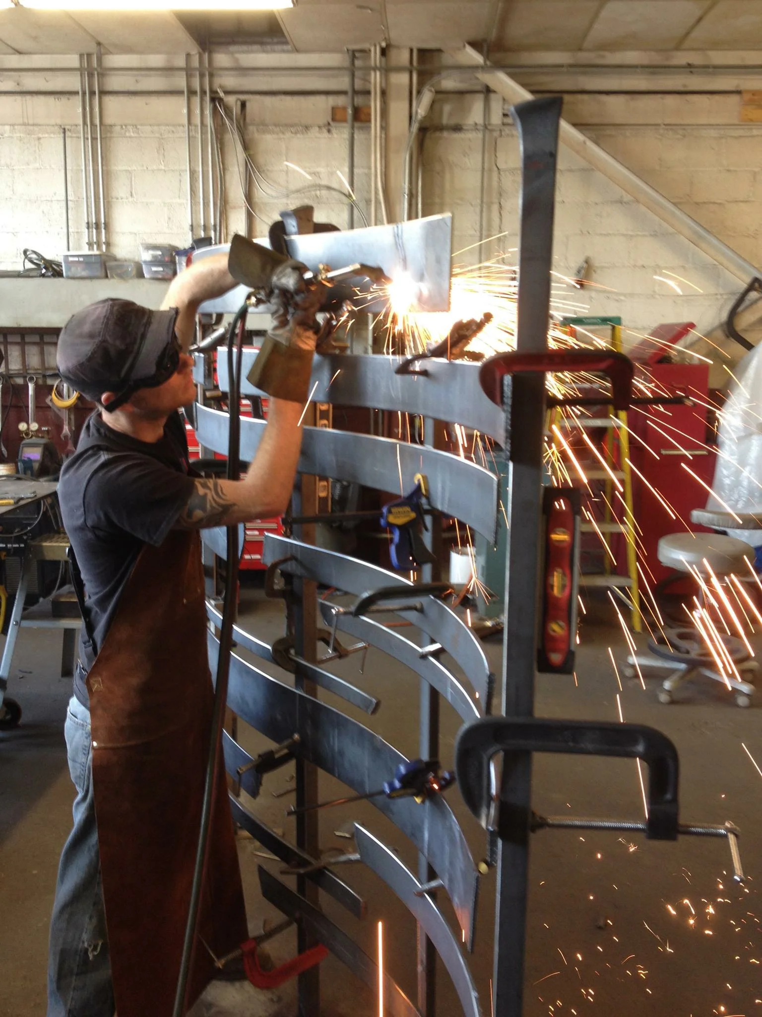 Welding elements of the custom garden sculptural screen in place