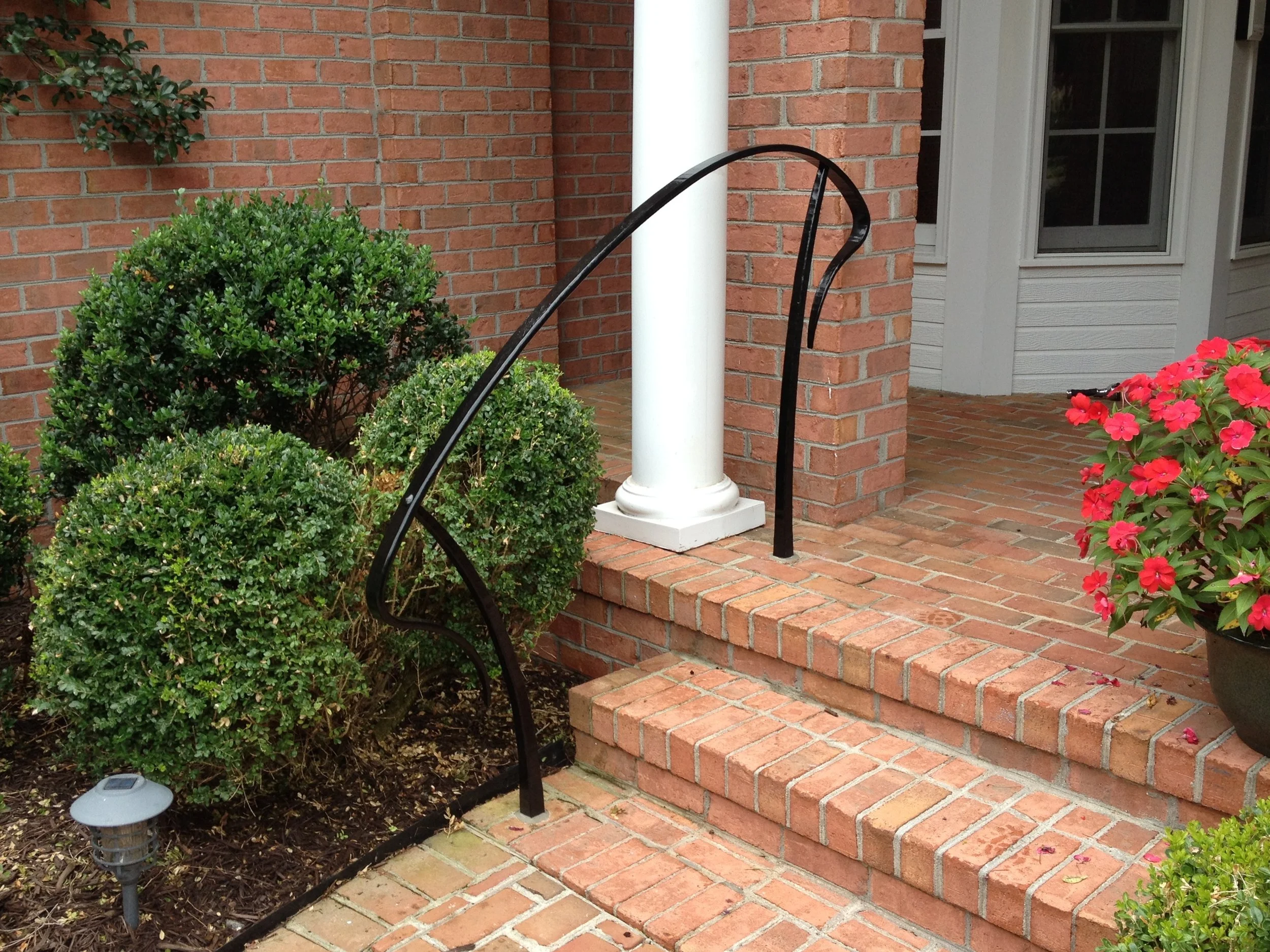 Hand-forged nouveau porch stair rail.