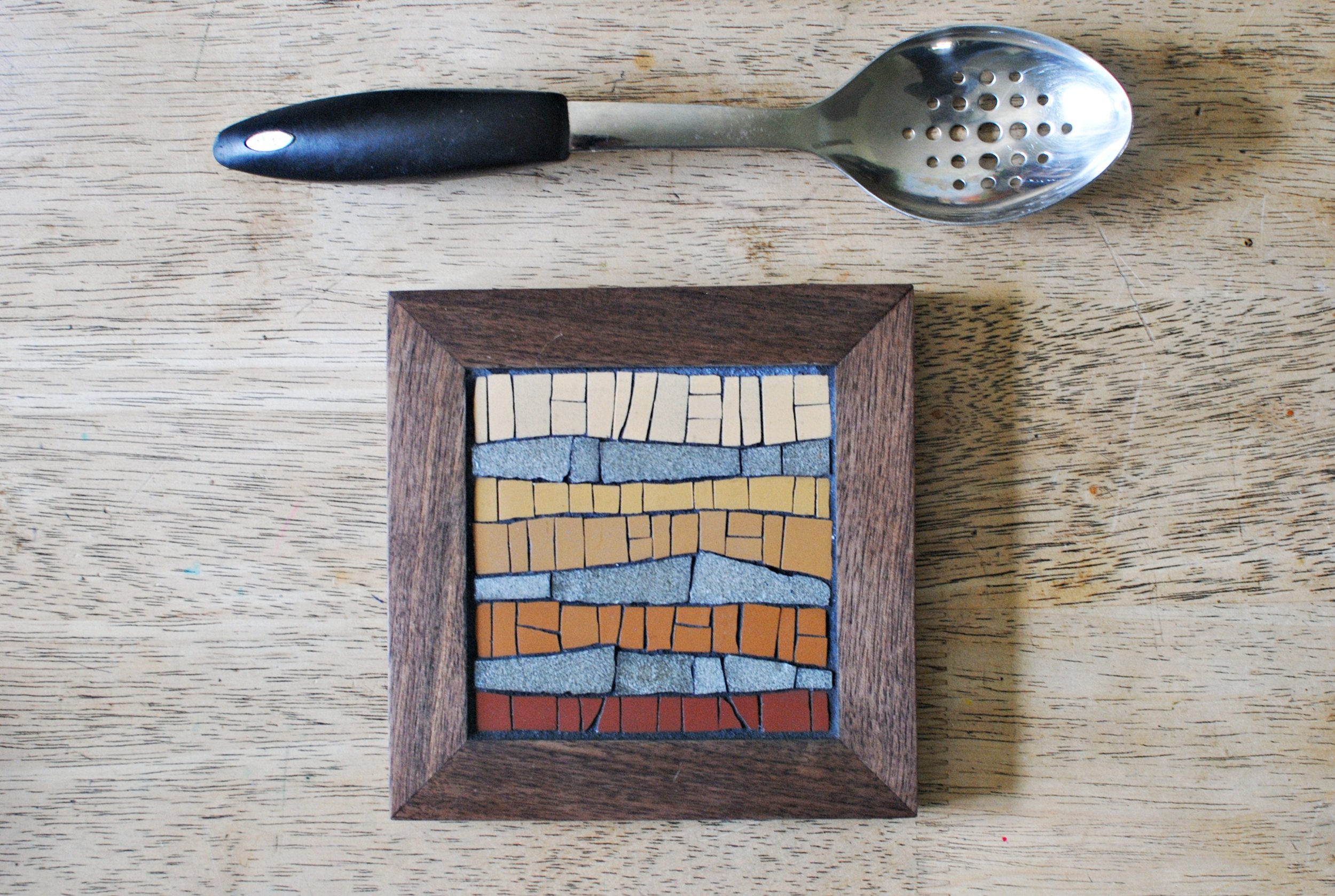 Desert mosaic trivet on table