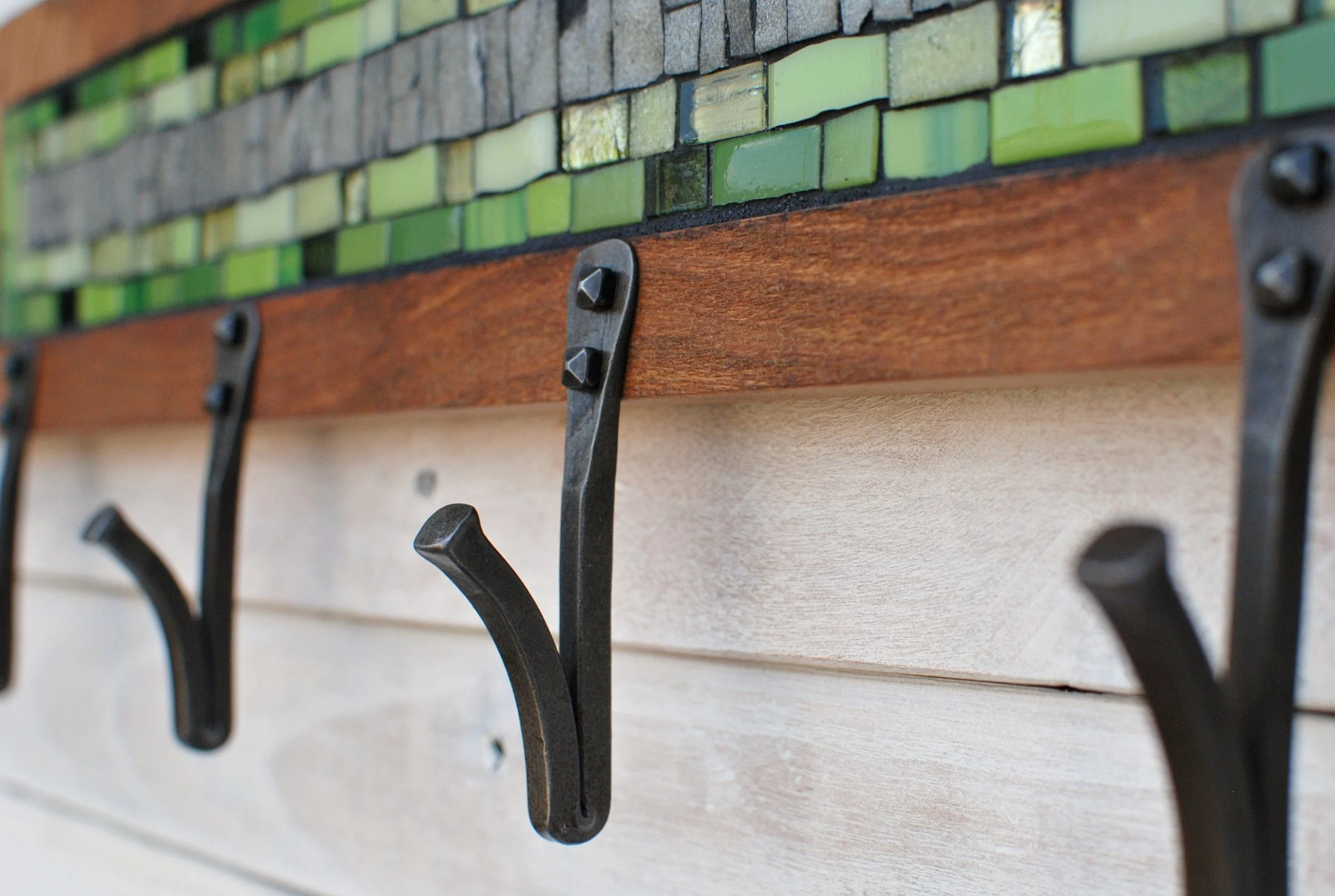 Detail photo of hand-forged hooks on mosaic coat rack