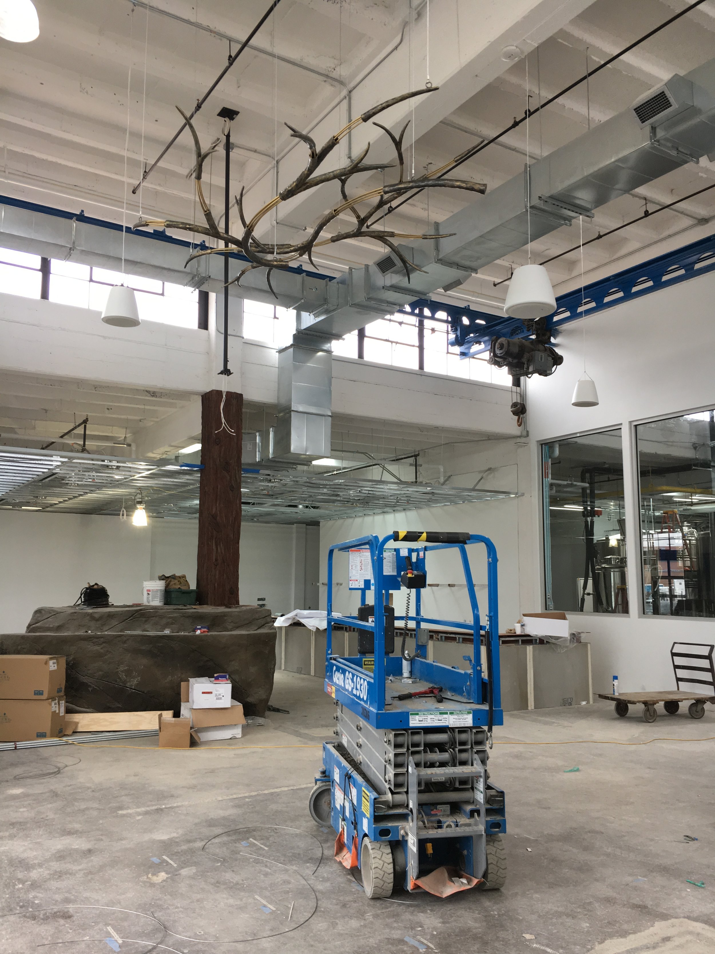 Installing the forged elements of the custom chandelier in the Vasen tasting room