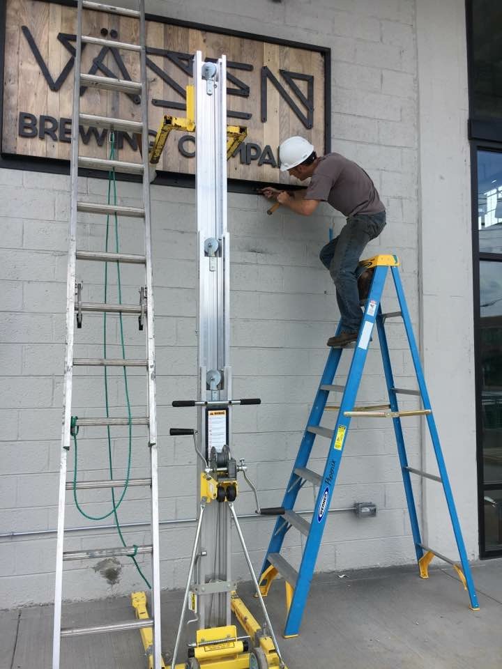 Installing the custom sign at the Vasen tasting room