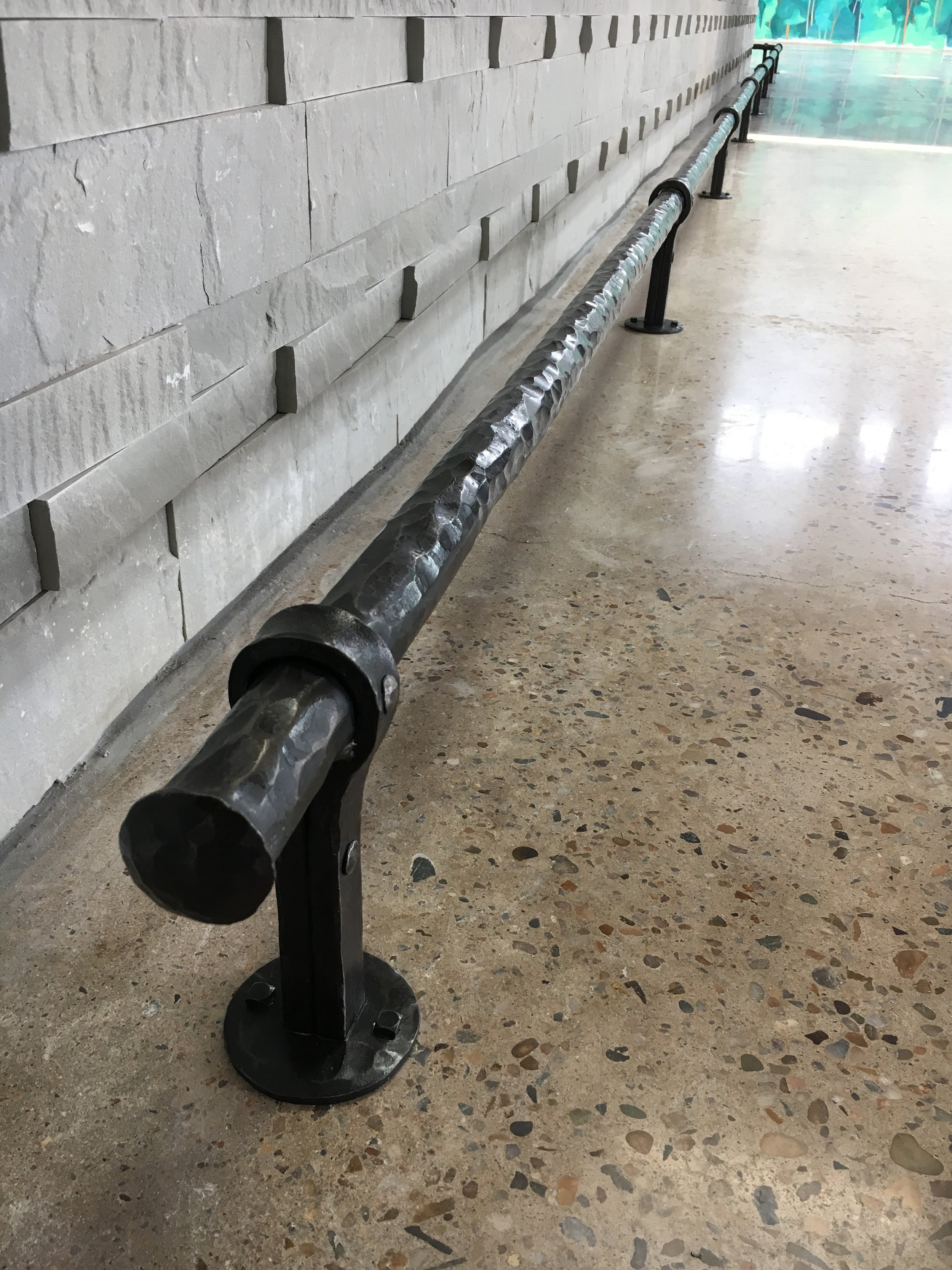 Forged custom bar foot rail installed at Vasen