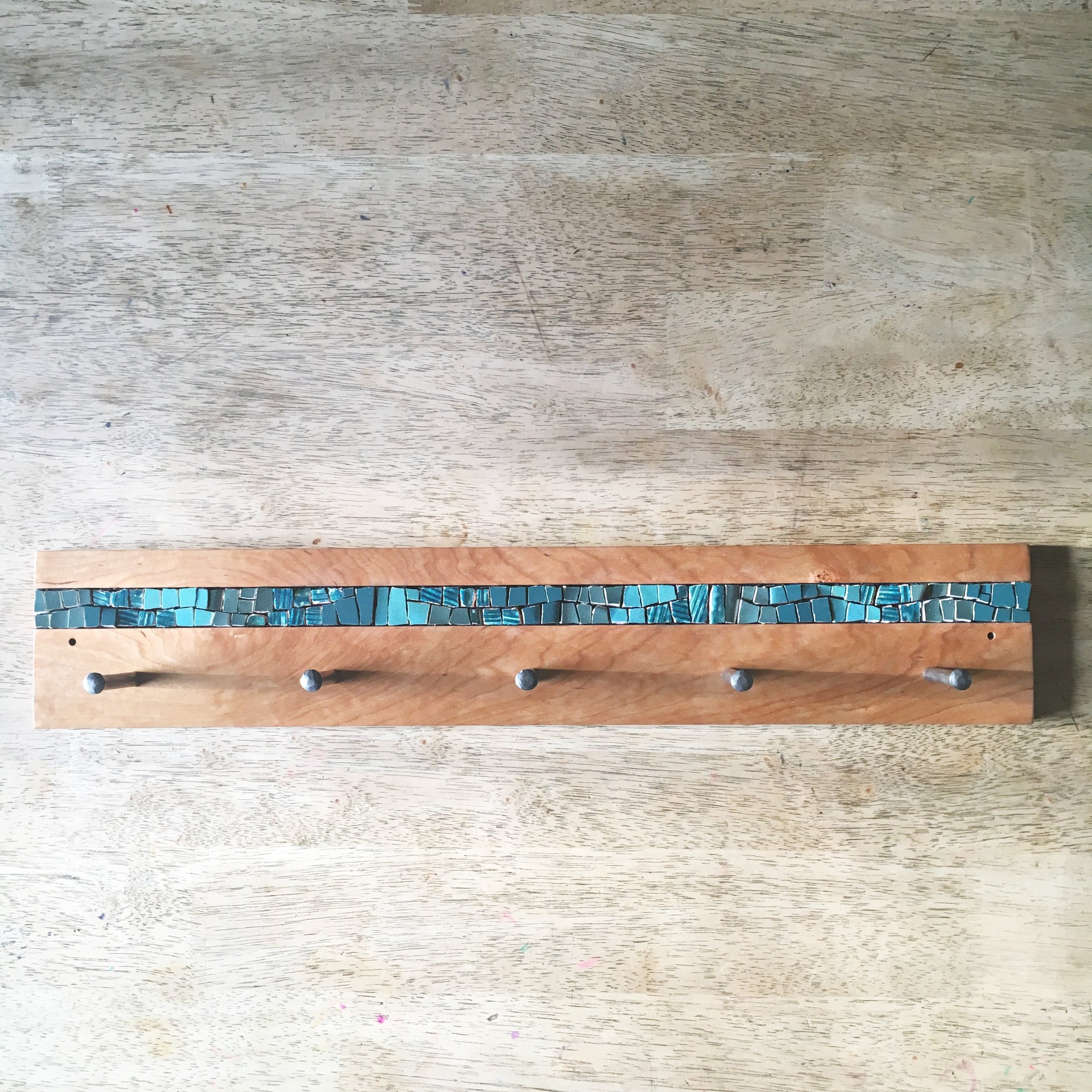 Teal mosaic coat rack with forged pegs