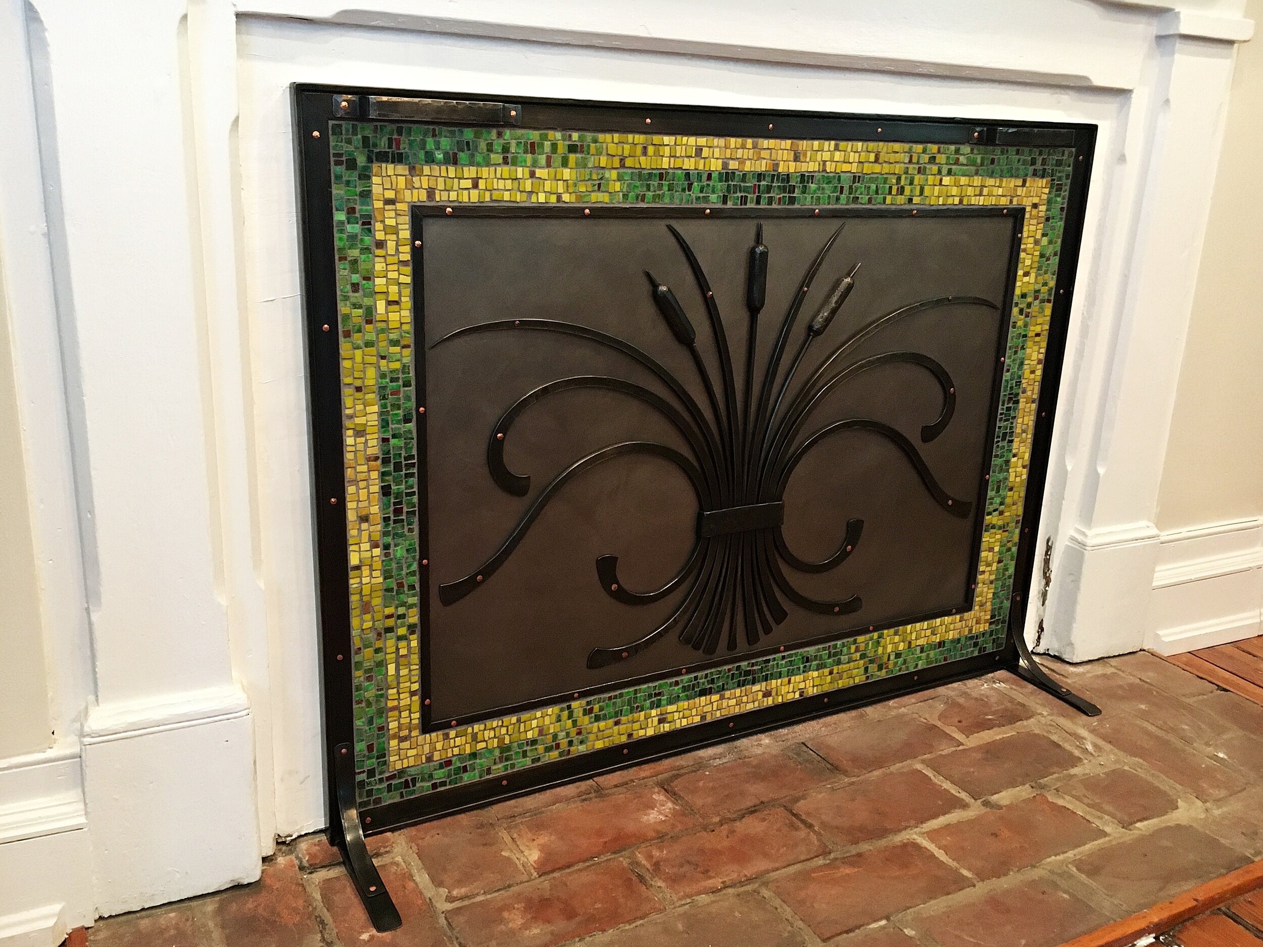 Custom forged steel and mosaic fireplace cover