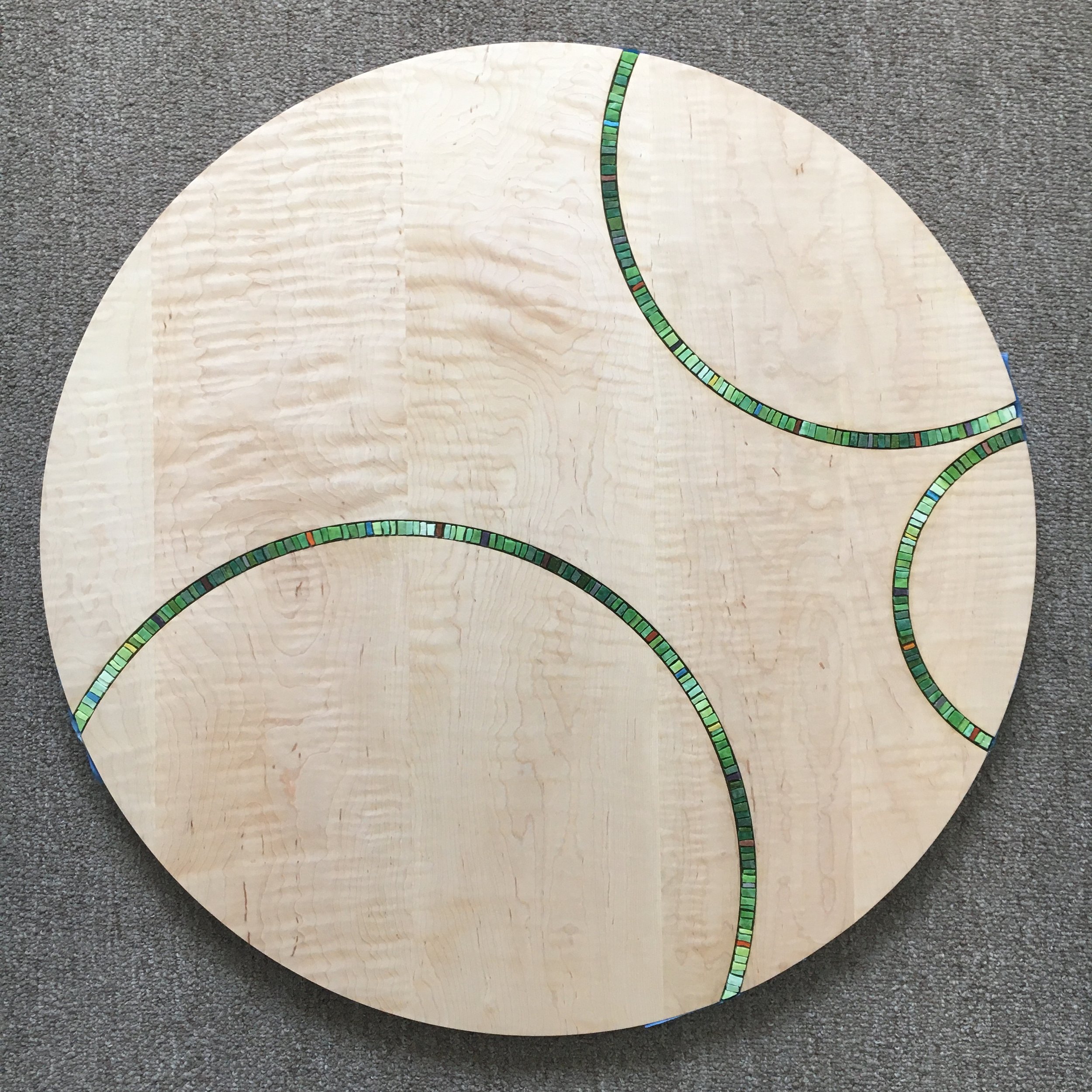 Green mosaic inlay in maple tabletop