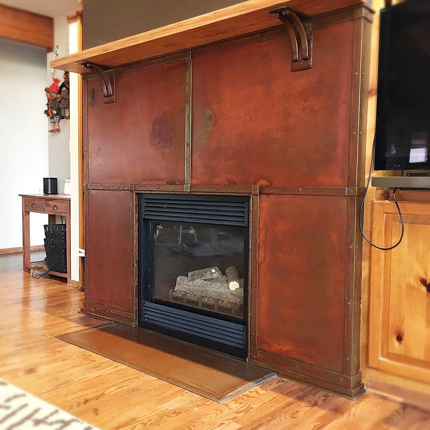 Fireplace surround with rust patina finish and mantle with hand-forged shelf brackets