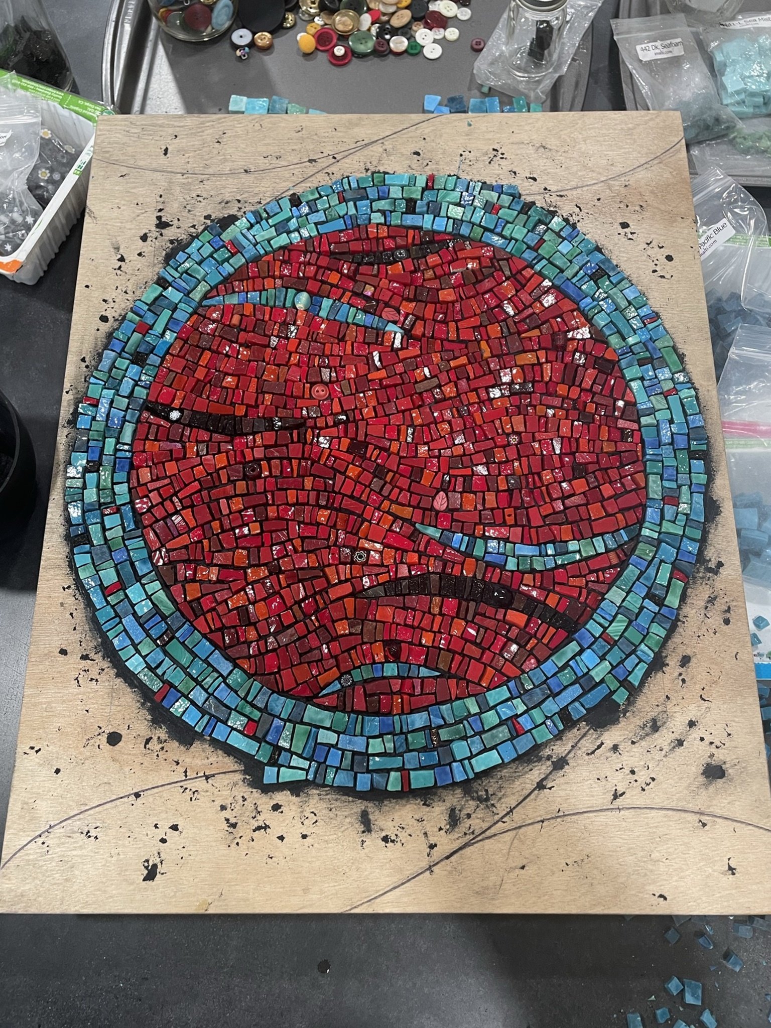 Red and blue circular mosaic art in progress