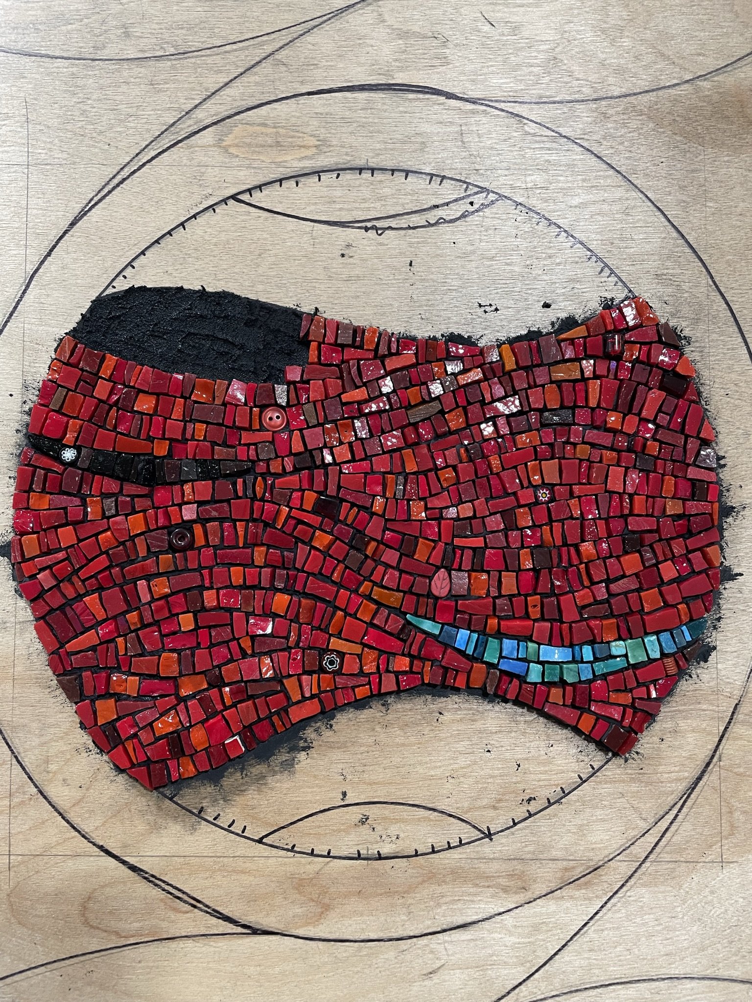 Red circular mosaic art in progress