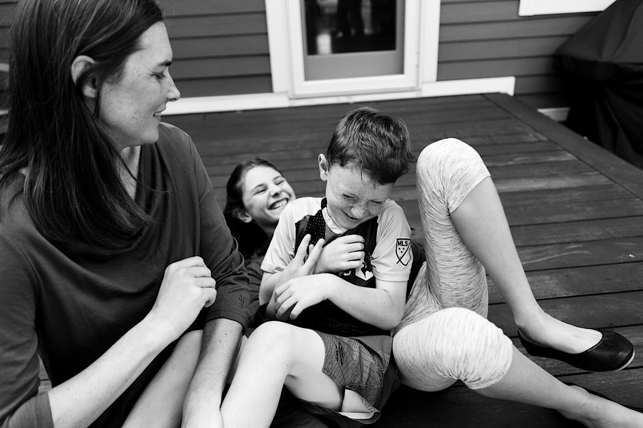 Siblings laughing together during a lifestyle portrait session in Saint Paul, Minnesota