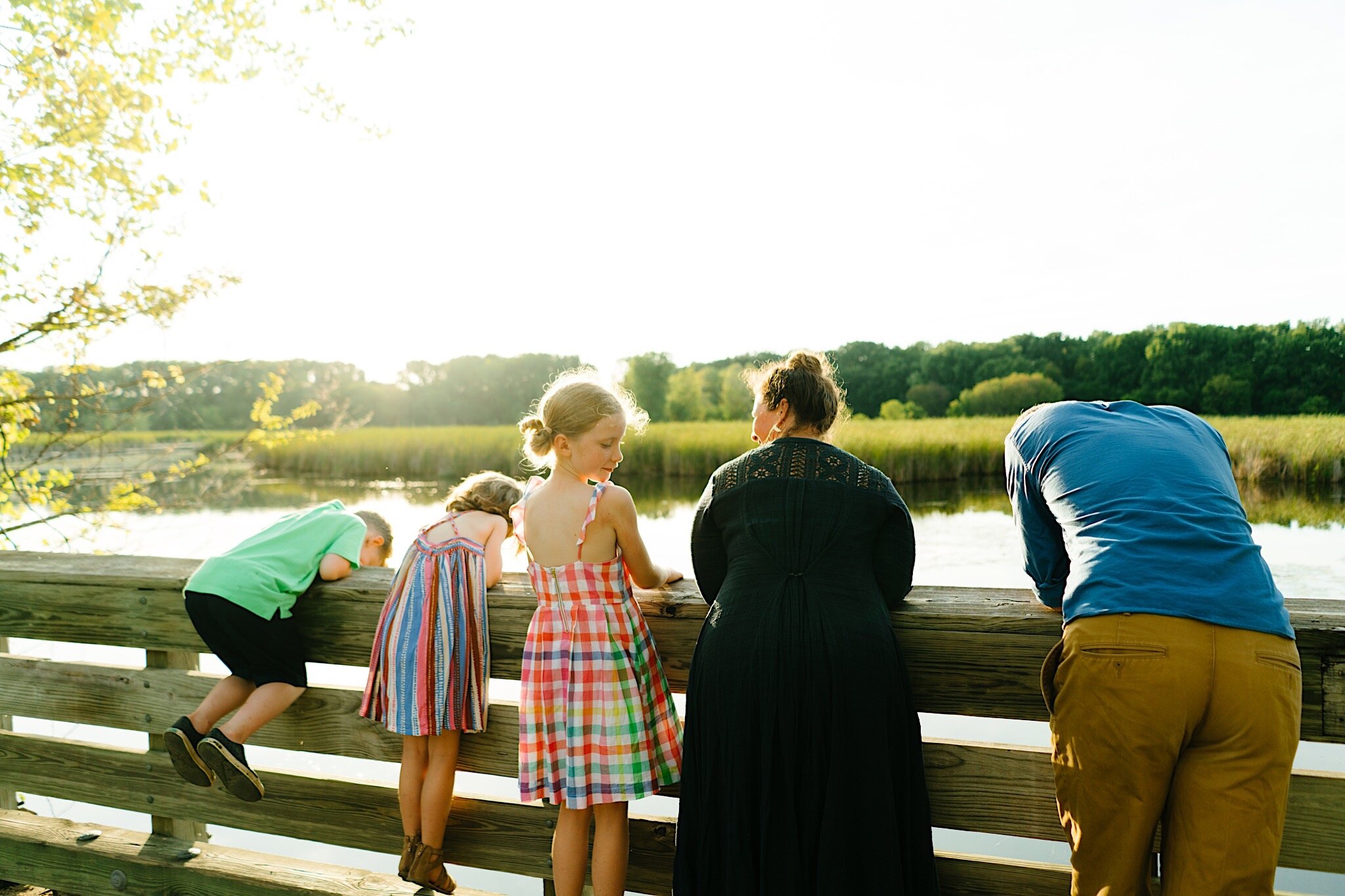 A family standing on a bridge together during modern family photos in the Twin Cities