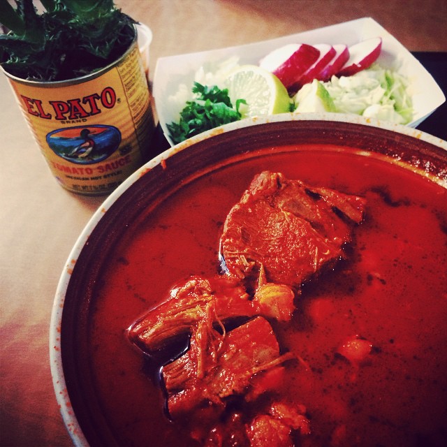 Bowl of pozole with toppings on the side. 