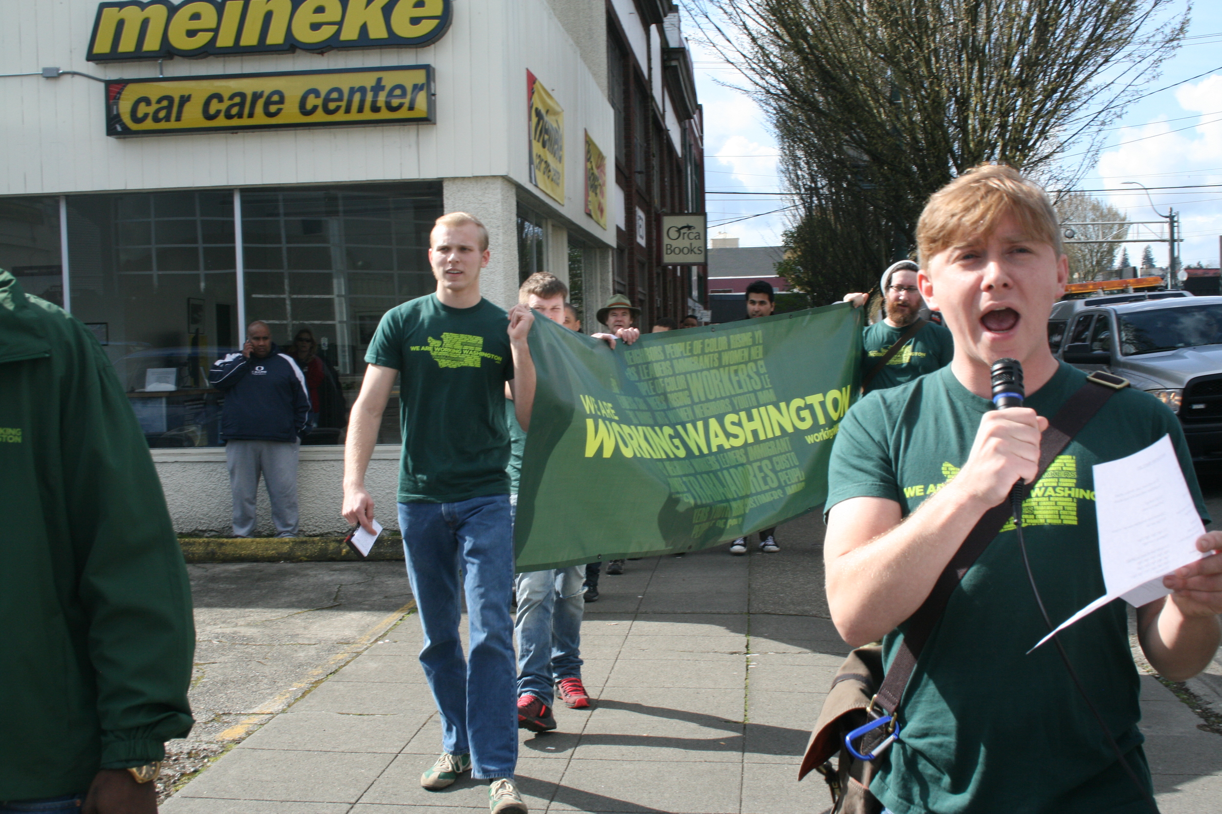 Luke Bridges, holding the Working Washington banner, spoke out why he is supporting $15 and workers' rights for Olympia.