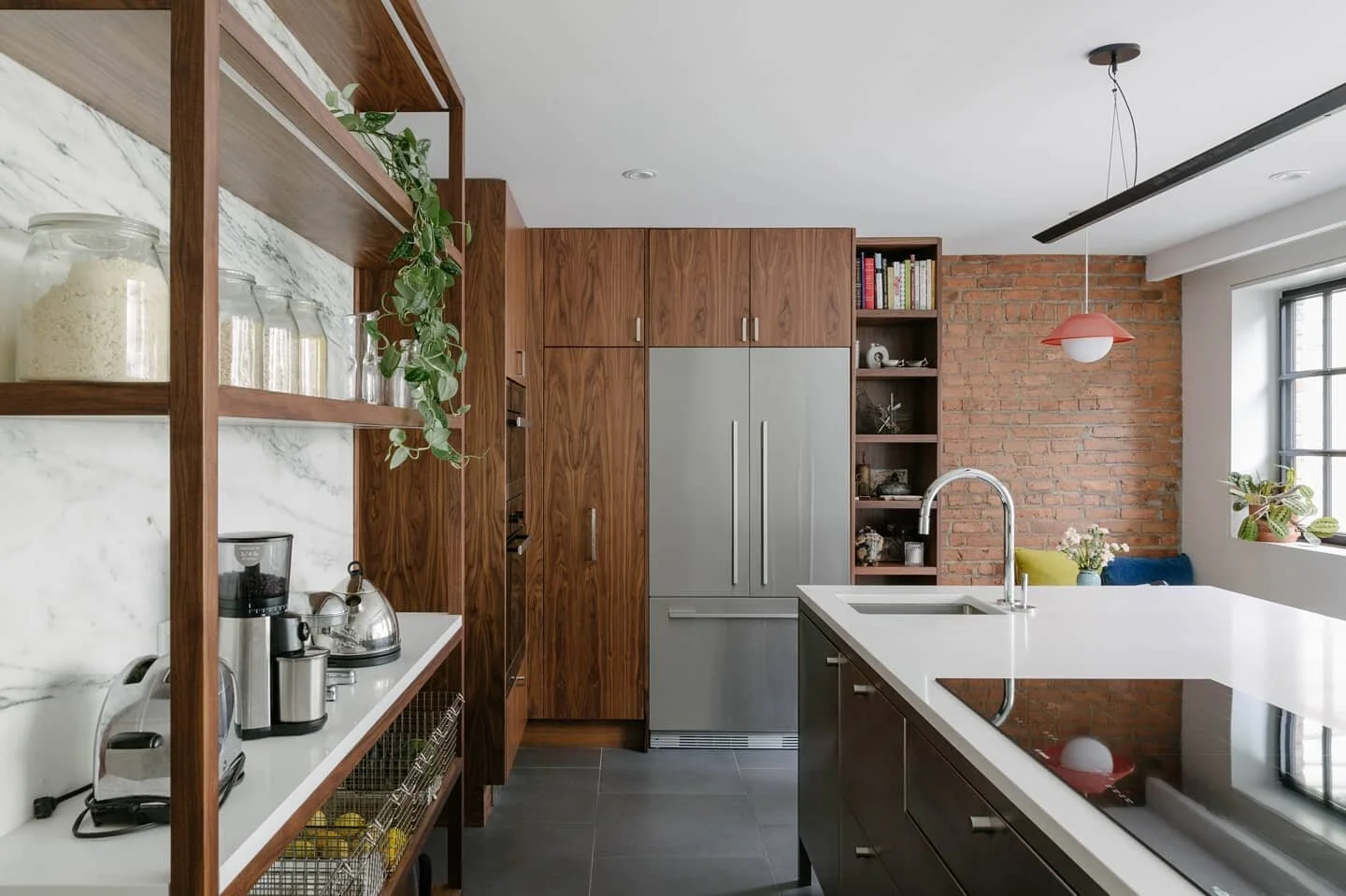 Daylit kitchen in the Sunset Park Townhouse. Walnut cabinetry plays well with the custom stainless island and exposed brick party wall. A new rear opening connects the kitchen, deck, and yard through steel french doors. Photos: @nickglimenakis

#jane
