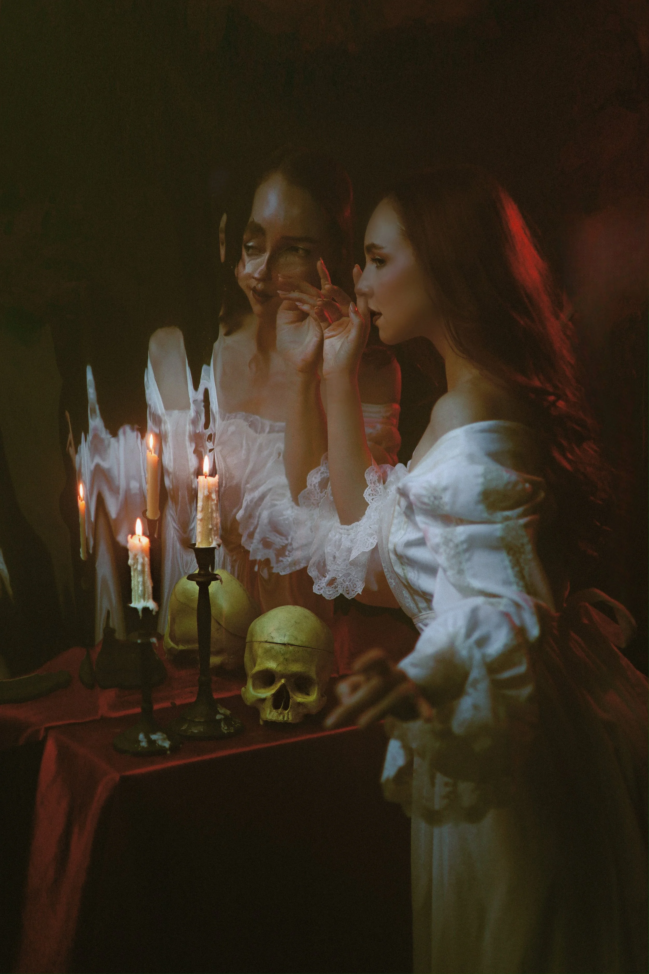 fine art portrait of a woman standing before a magic mirror with candles and a skull