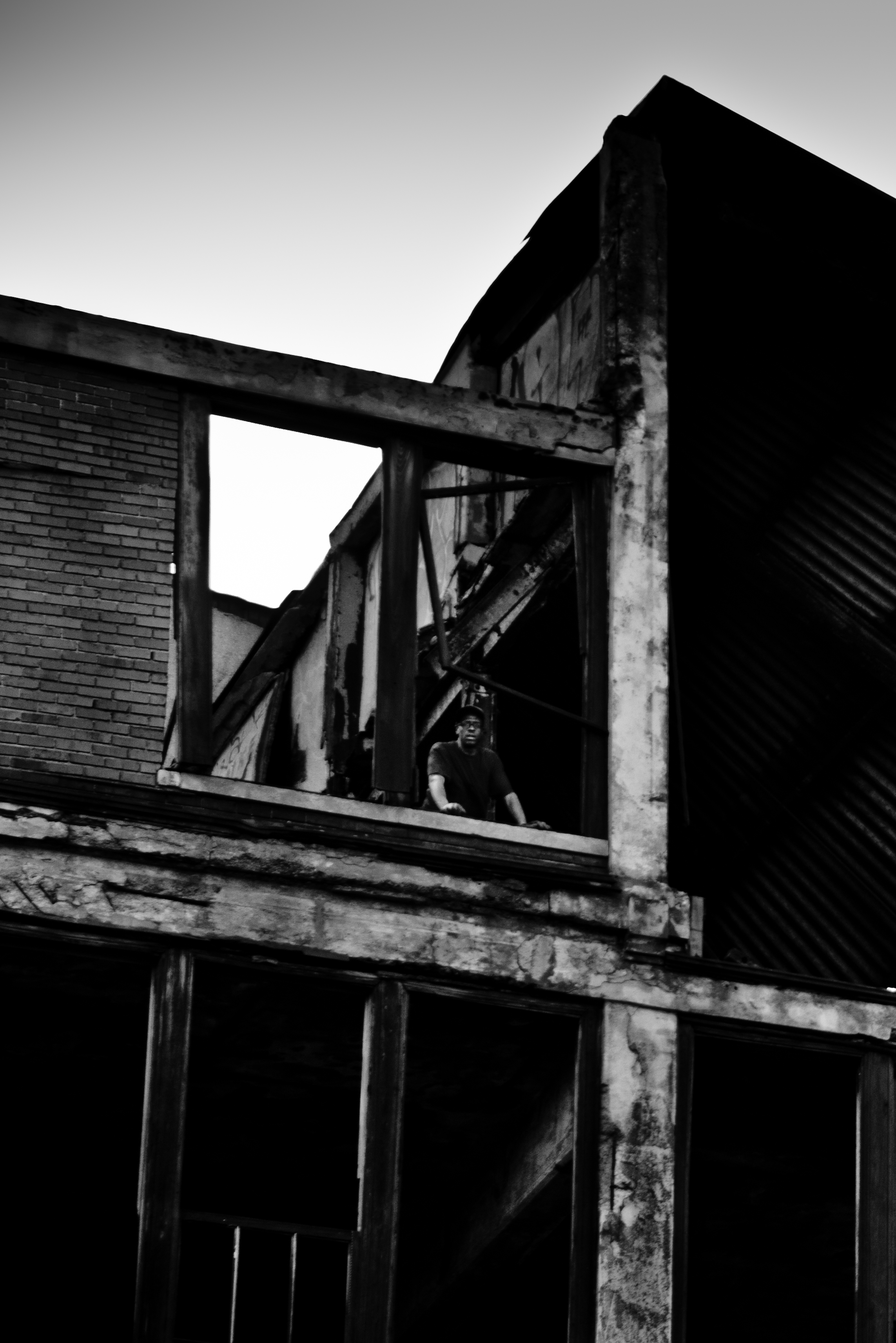  A scrapper looks down from the fifth floor of the Packard Plant to speak to his partner. Packard Plant, Detroit.&nbsp; 