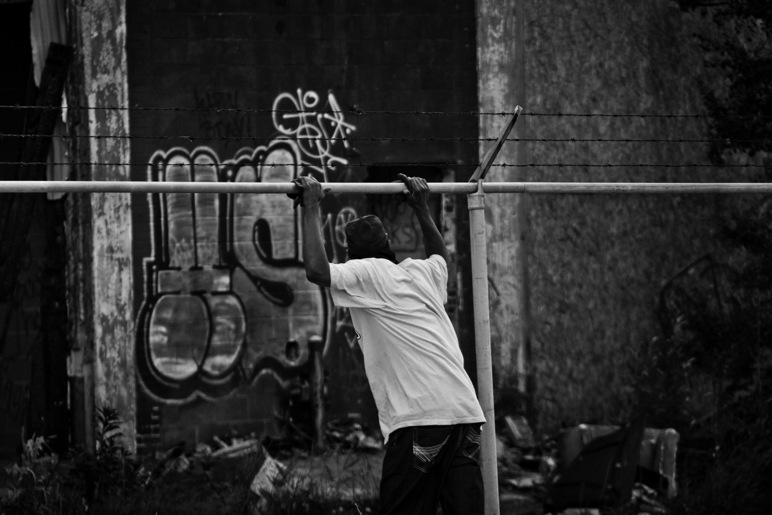  A man keeps watch for police and traffic as his partner scraps metal above. Packard Plant, Detroit.&nbsp; 