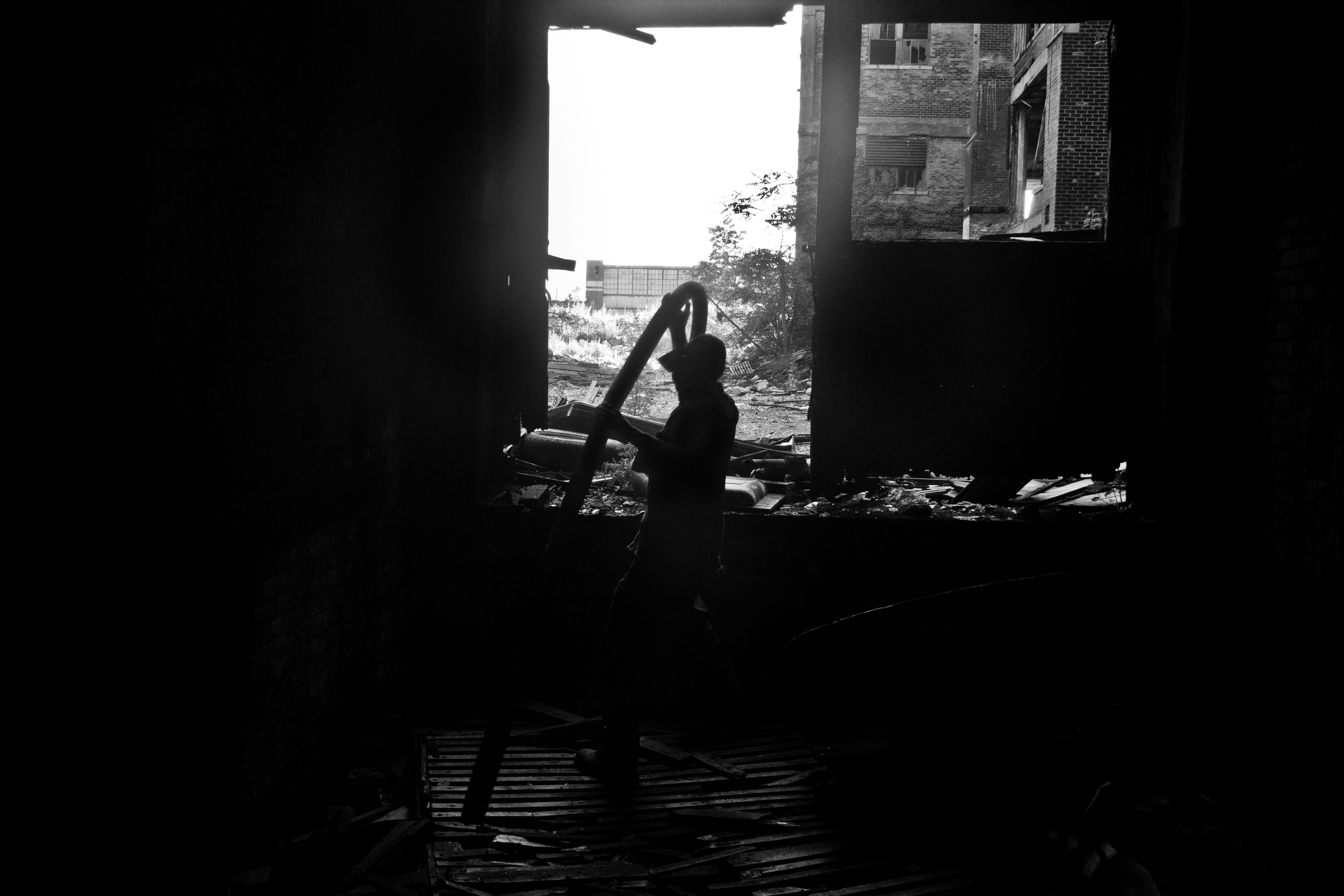 A scrapper lifts heavy metal out of an abandoned elevator shaft at the Packard Plant, Detroit. 