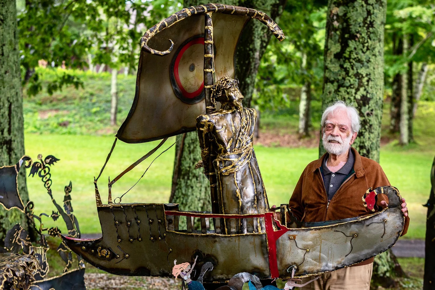a man sitting in a chair with a large sword and shield