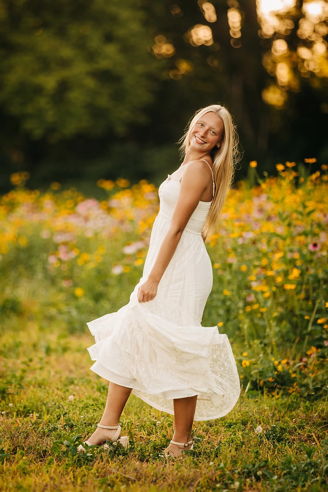 Northwestern Lehigh High School senior twirling in a white dress during her golden hour senior session in a Lehigh Valley wildflower field.