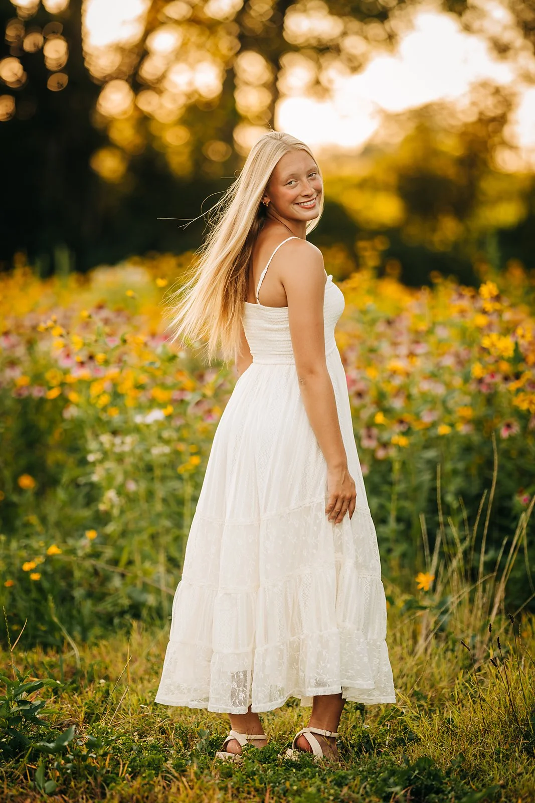 Northwestern Lehigh High School senior twirling in a white dress during her golden hour senior session in a Lehigh Valley wildflower field.
