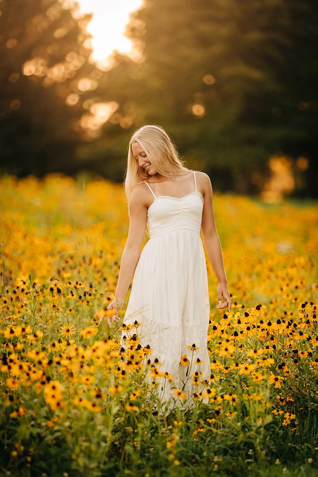 Senior portrait of Kherinton surrounded by yellow wildflowers during golden hour in the Lehigh Valley
