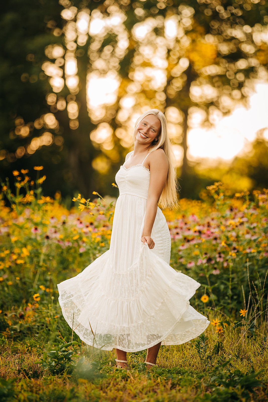 Northwestern Lehigh High School senior twirling in a white dress during her golden hour senior session in a Lehigh Valley wildflower field.