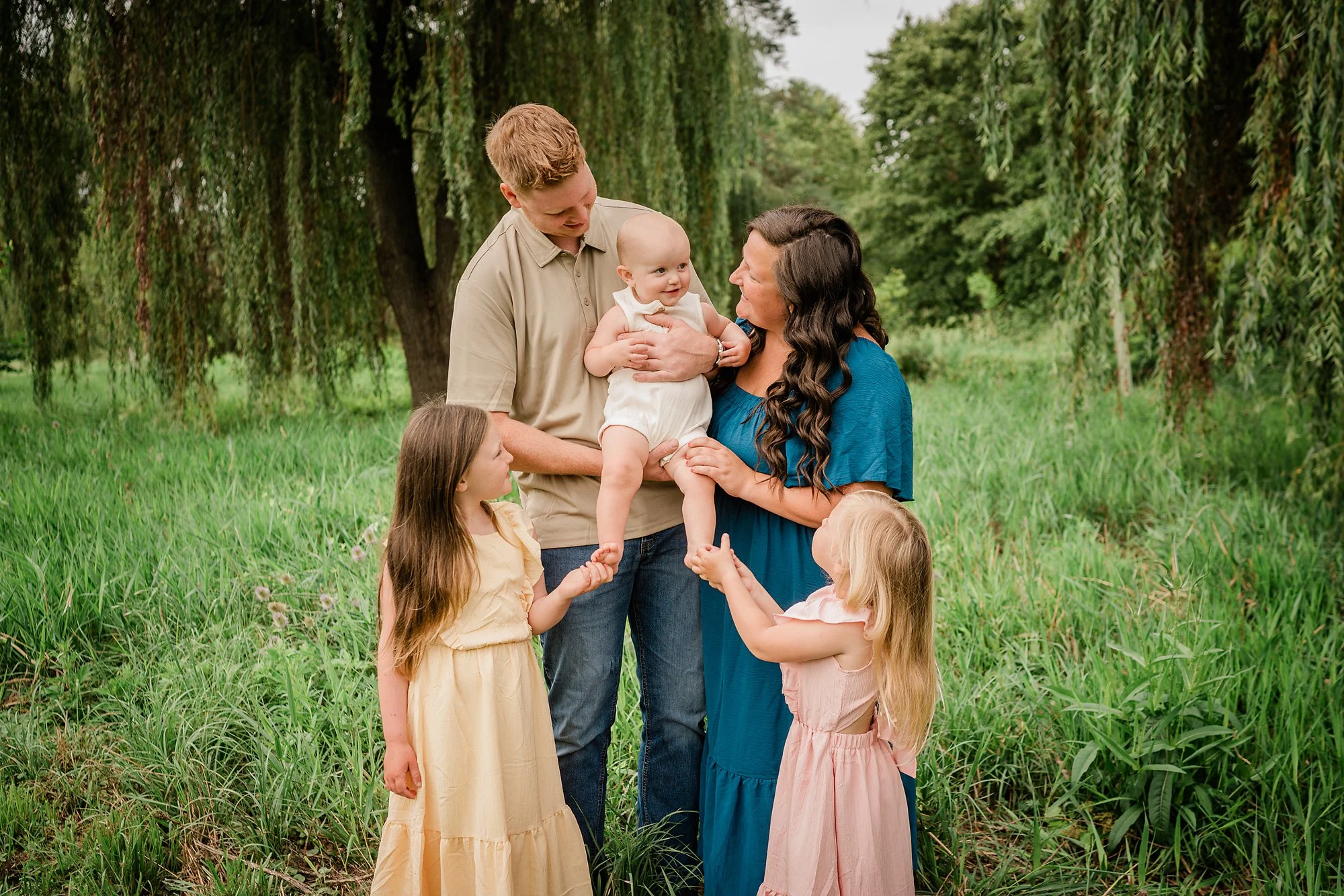 Baby smiling at parents during a natural outdoor family photography session in Easton, Pennsylvania.
