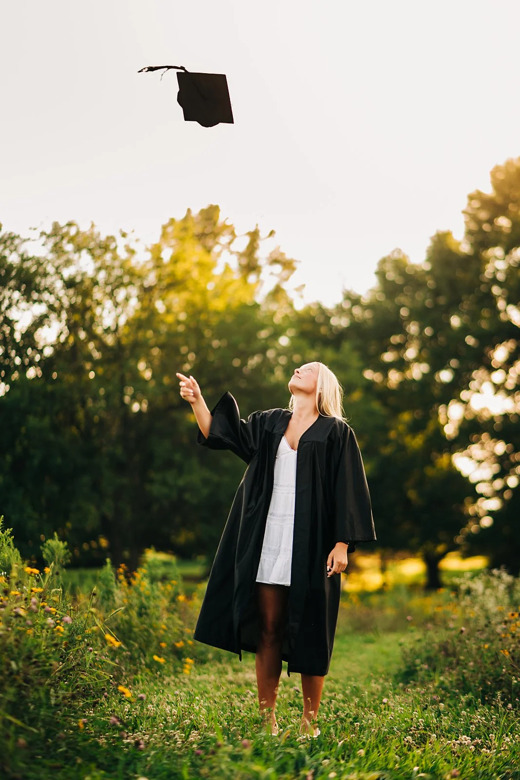 High school senior tossing her graduation cap during an outdoor senior photography session in the Lehigh Valley