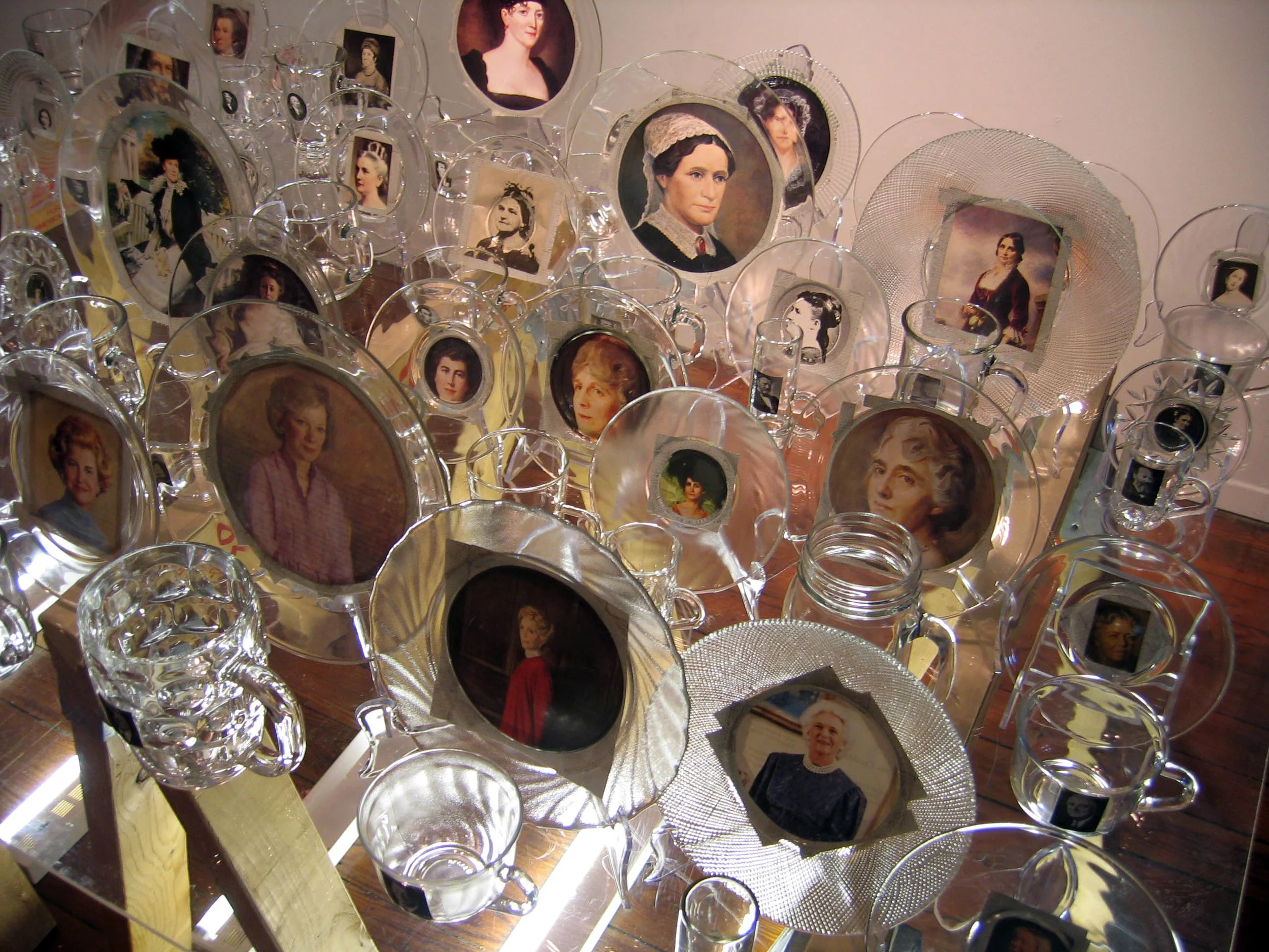 First Love (detail), 2007, Glass, paper, tape, plexiglass, wood and fluorescent lights 41 cups with president, 41 saucers with first lady, 4 x 3 x 3'