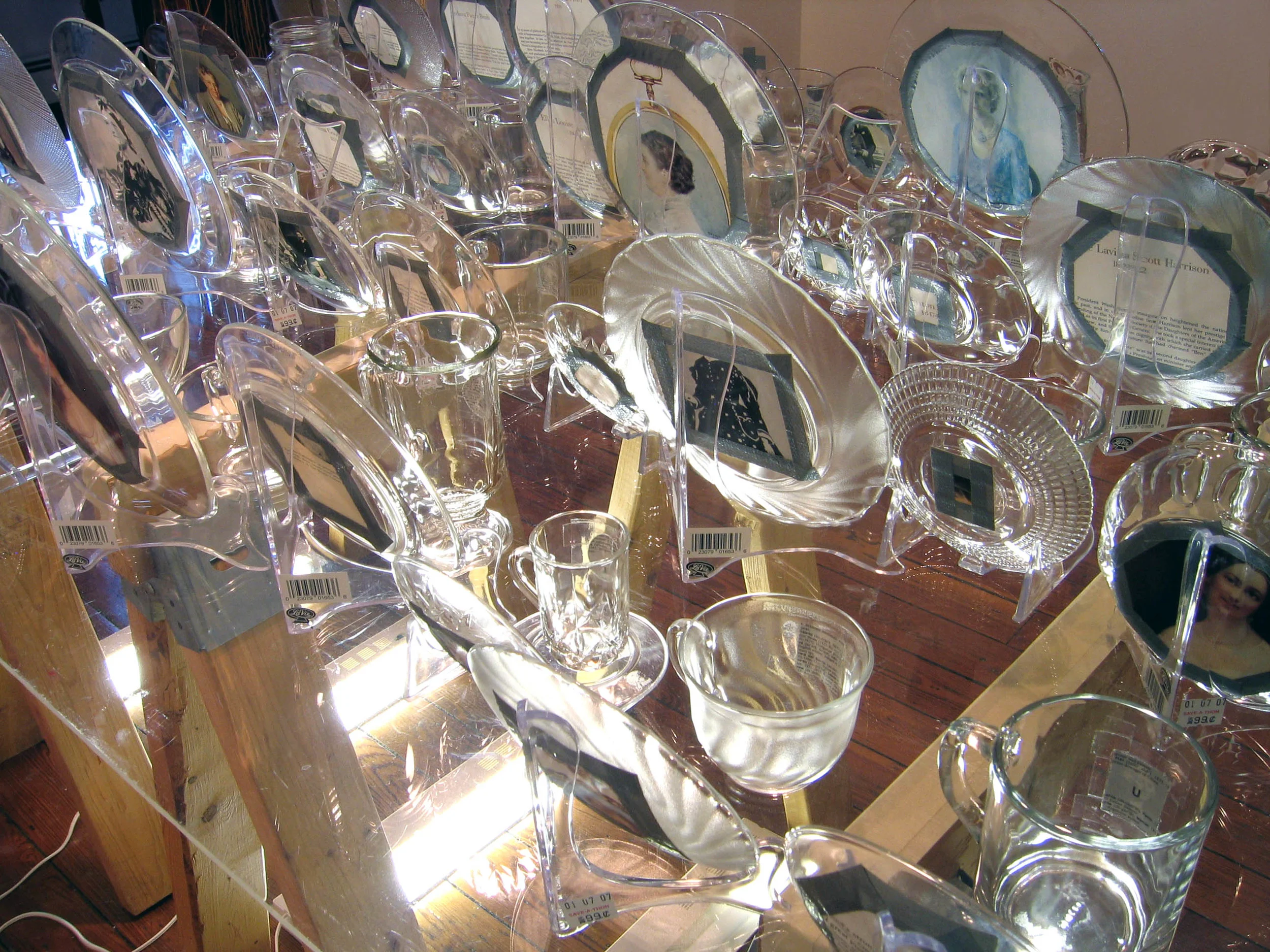 First Love (detail back), 2007, Glass, paper, tape, plexiglass, wood and fluorescent lights 41 cups with president, 41 saucers with first lady, 4 x 3 x 3'