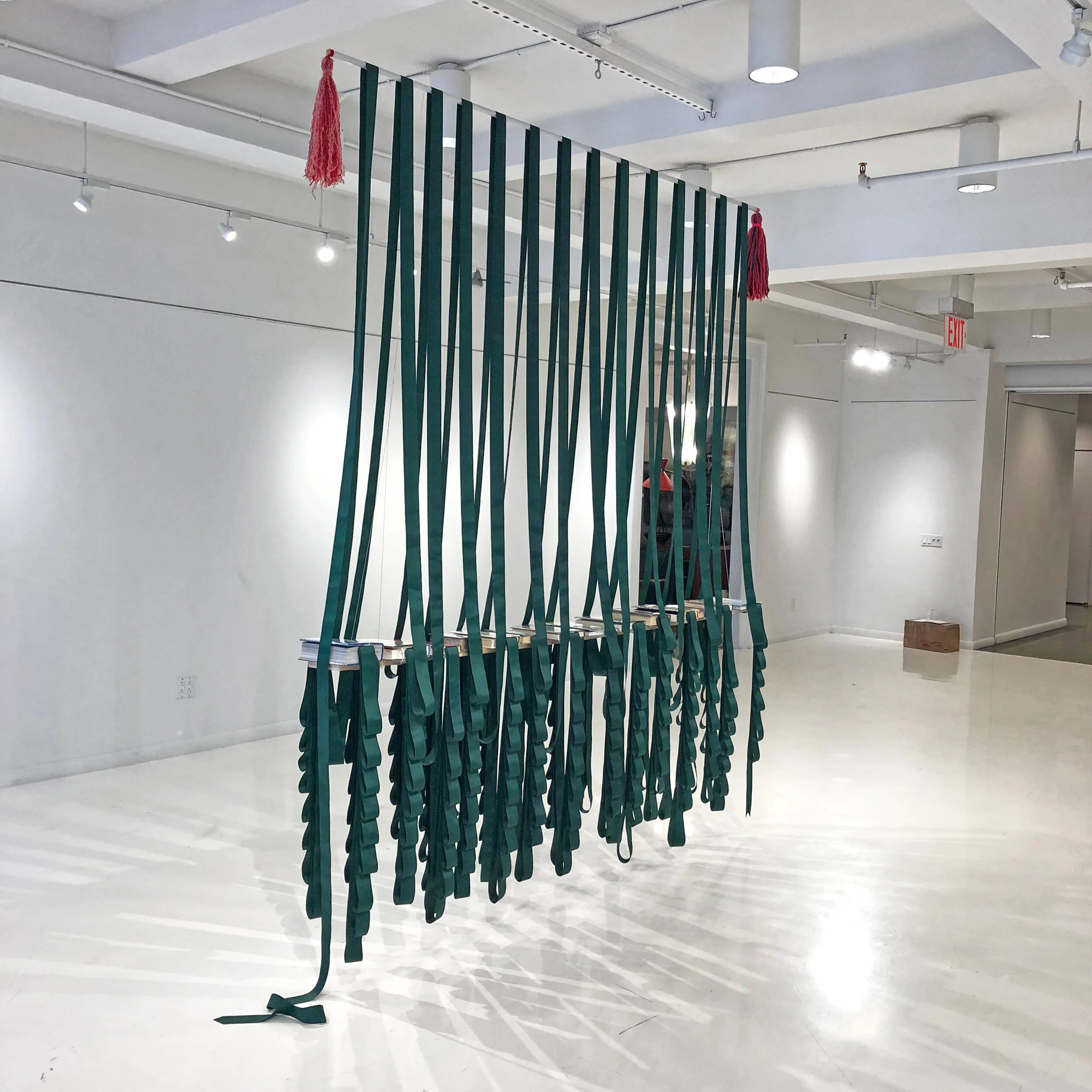 Bookmark, 2018, 13 Library books, wood, metal, yarn, clippings, tape, and one long-continuous grosgrain ribbon bookmark, 8’ x 6” x 8’