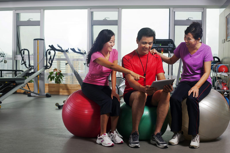 group-in-gym-on-exercise-balls-looking-at-tablet.jpg