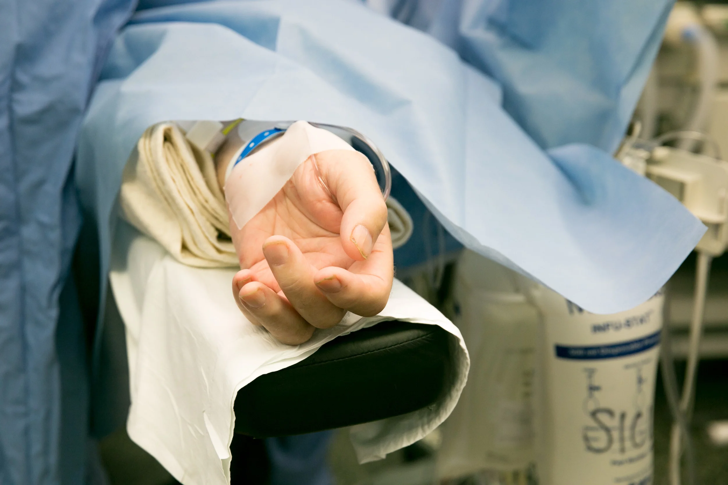  A patient's hand lies on the operating table. 