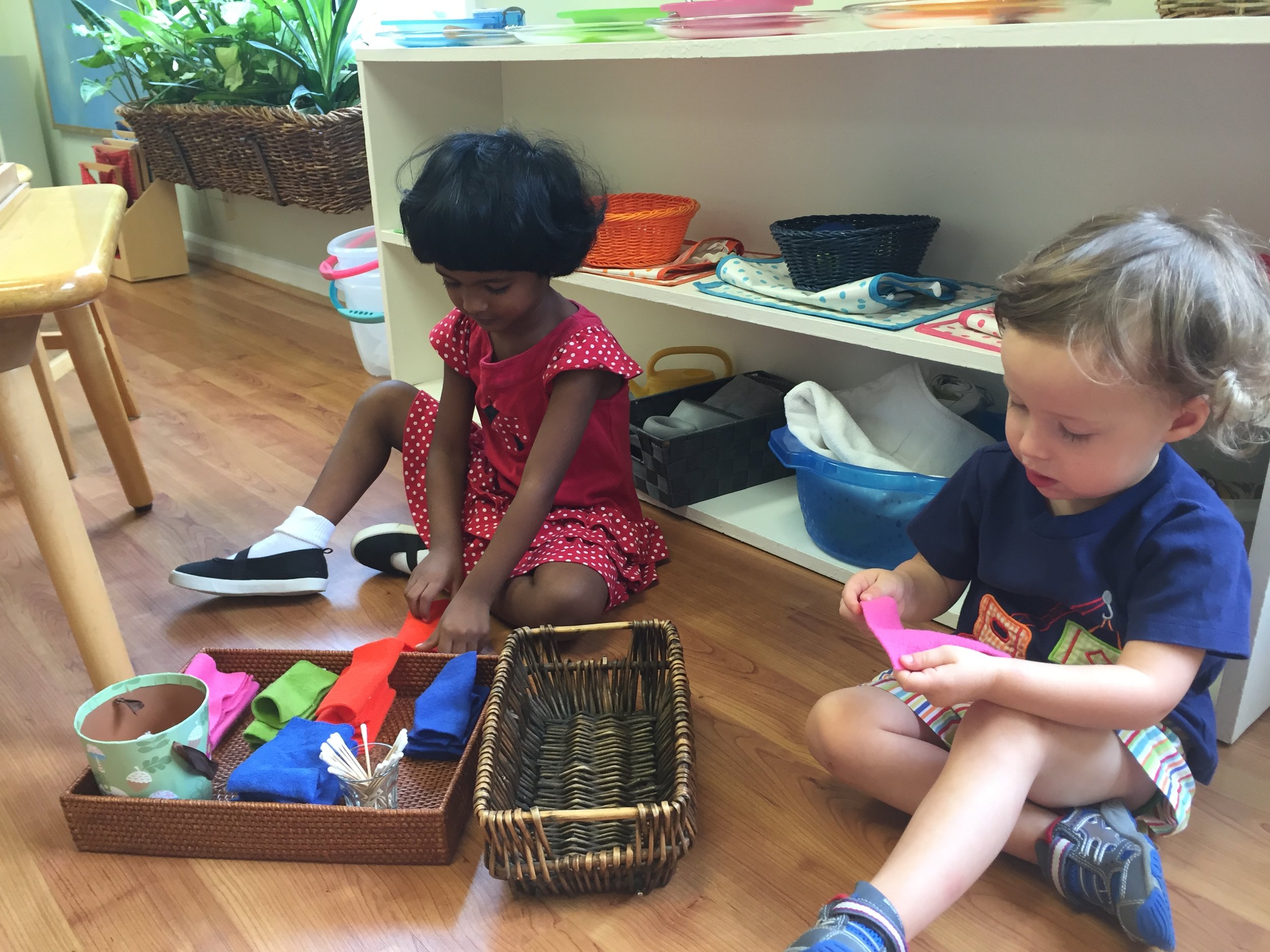 Two three year old children work together to fold the class polishing cloths. We are enjoying our new polar fleece cloths. 
