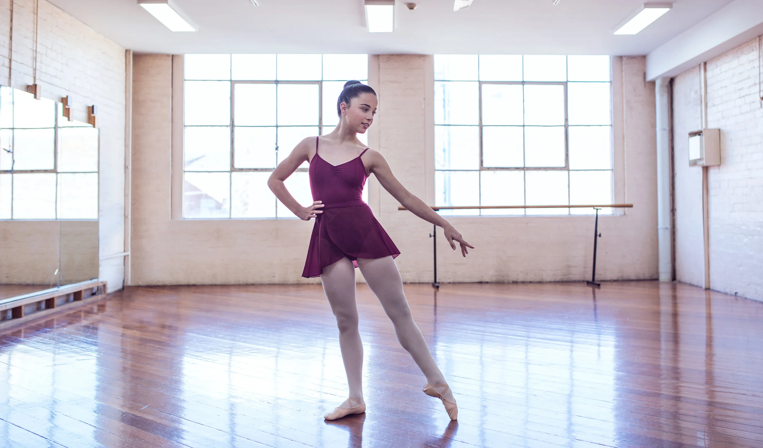 Ella wears Energetiks Princess Line Camisole in Burgundy and Burgundy Wrap Skirt