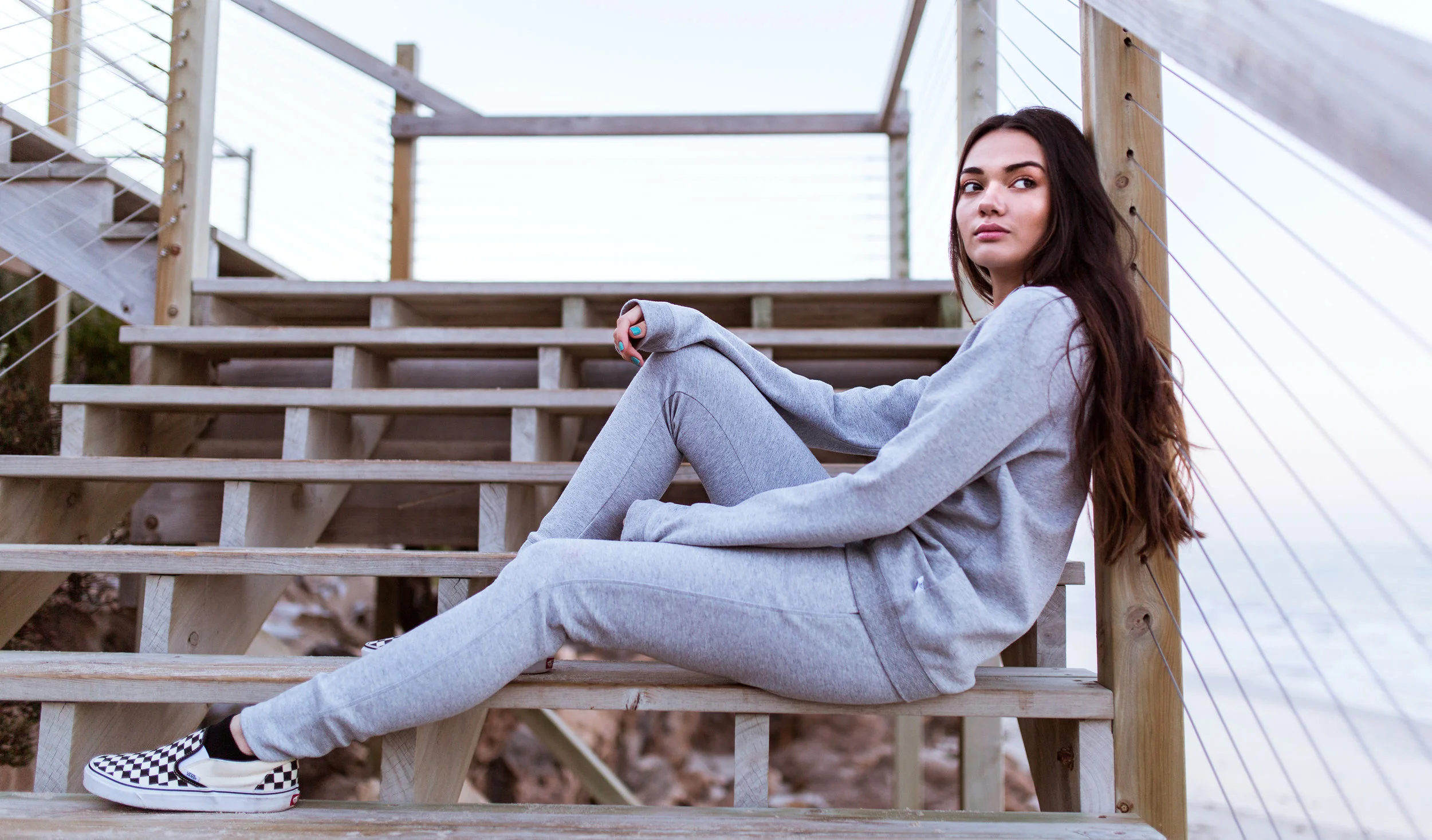 Portia wears the Delta Hoodie in Grey Marle, and the Avery Track Pants from the Paradise Collection