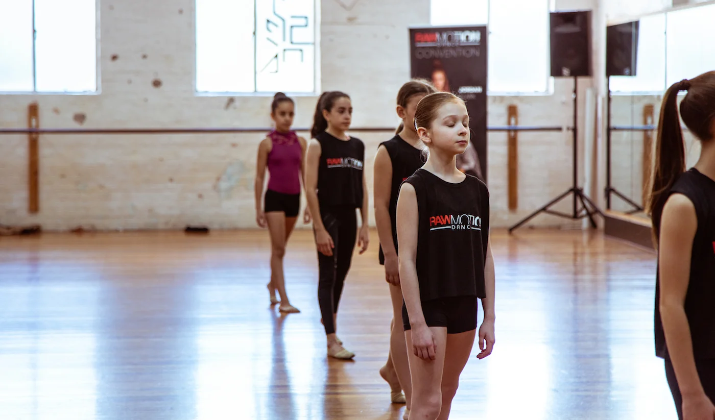 Students absorbed in an under 14’s contemporary class, sporting the offical tour merchandise t-shirts, proudly made by Energetiks.