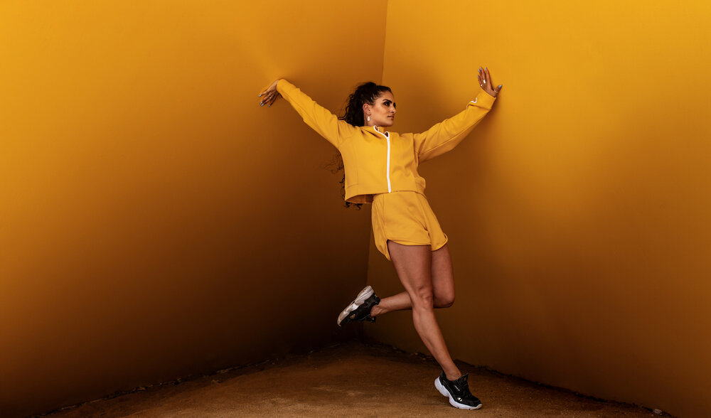 Luca wears the Wilder Jacket and Jada Short in Flame from the ROAR by Yvette Lee Collection .