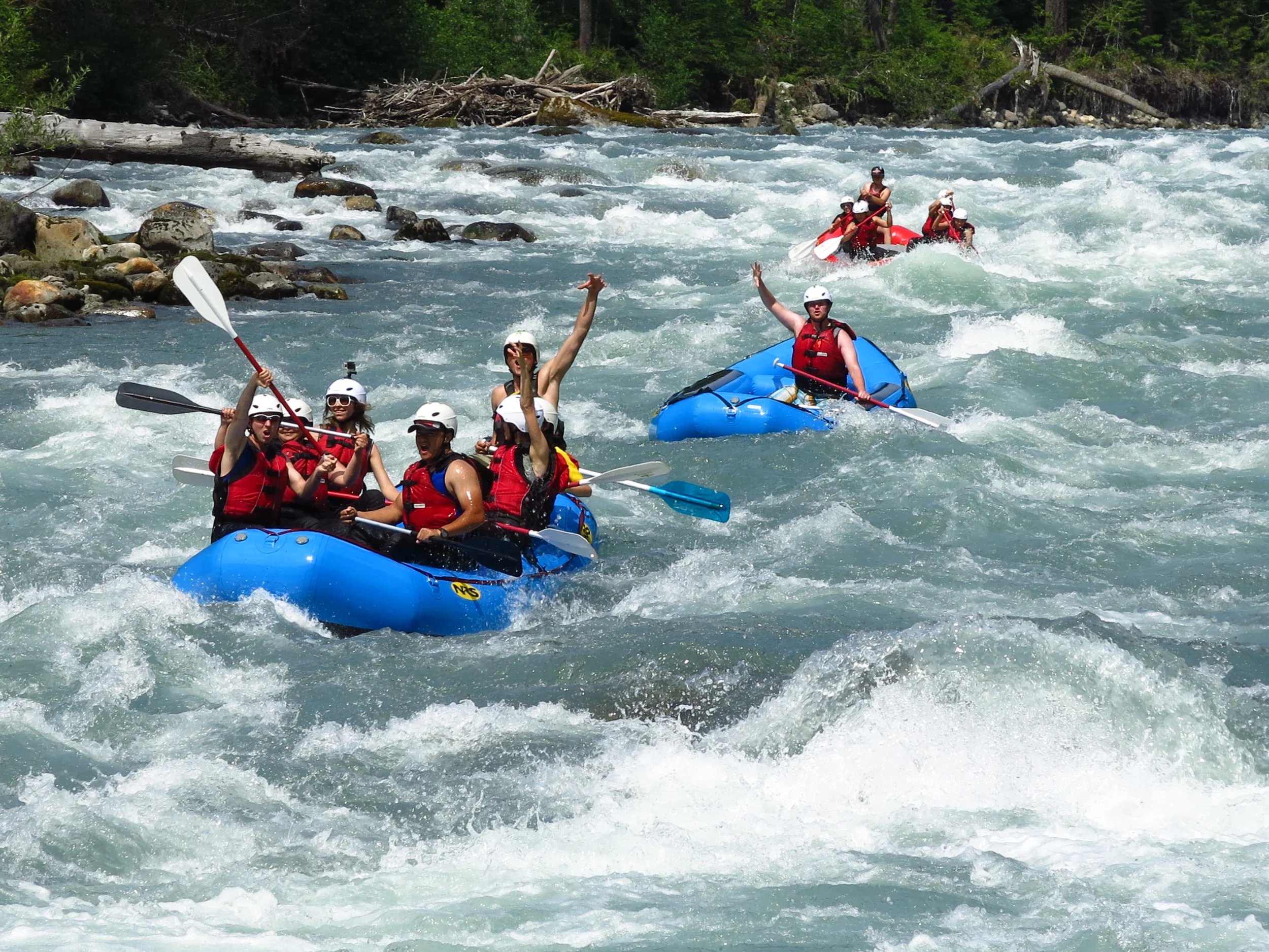 Rafts wave at the camera while going through Whirlpool Rapid on the Sauk River