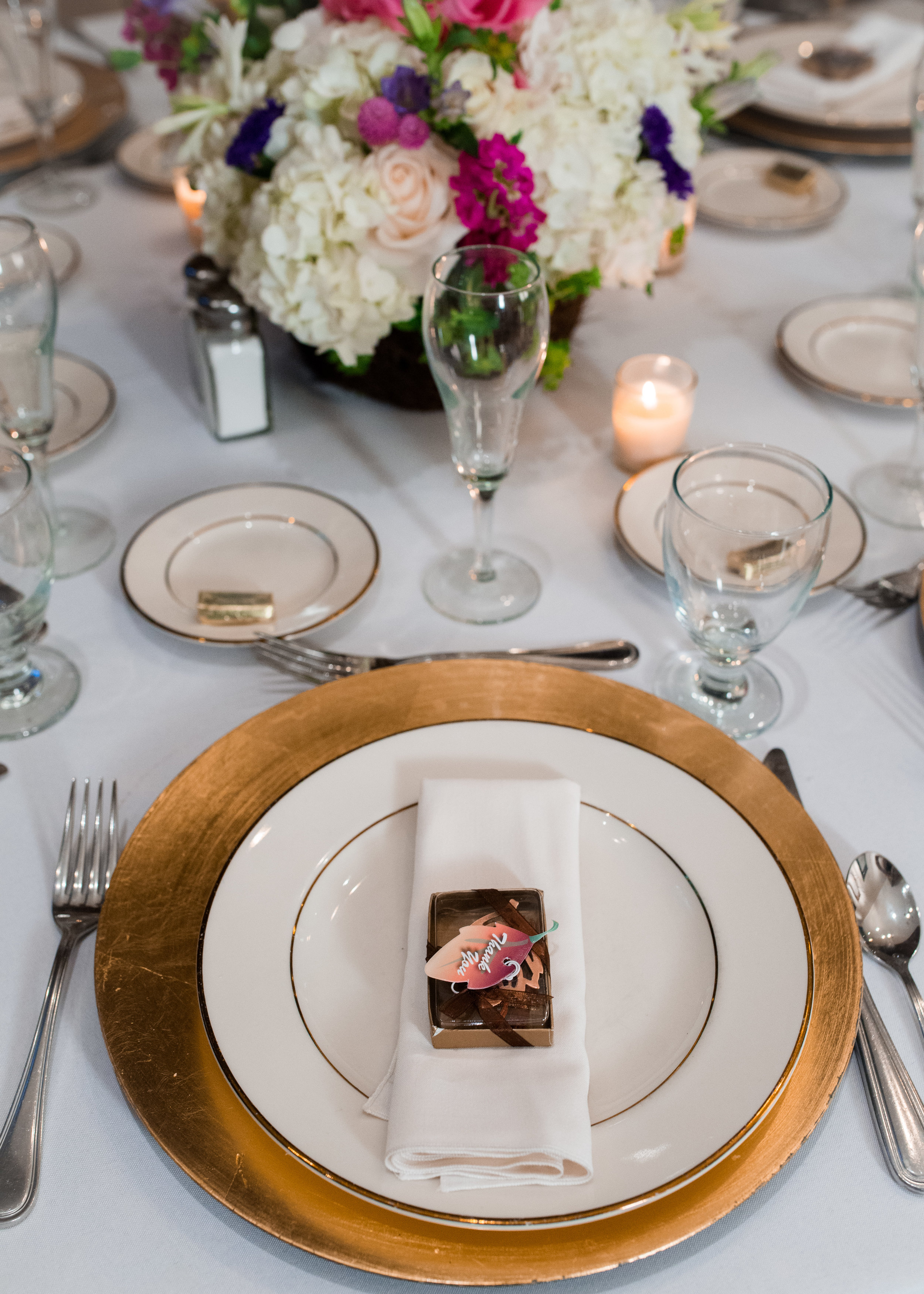 Gold chargers and chocolate treats for the guests.